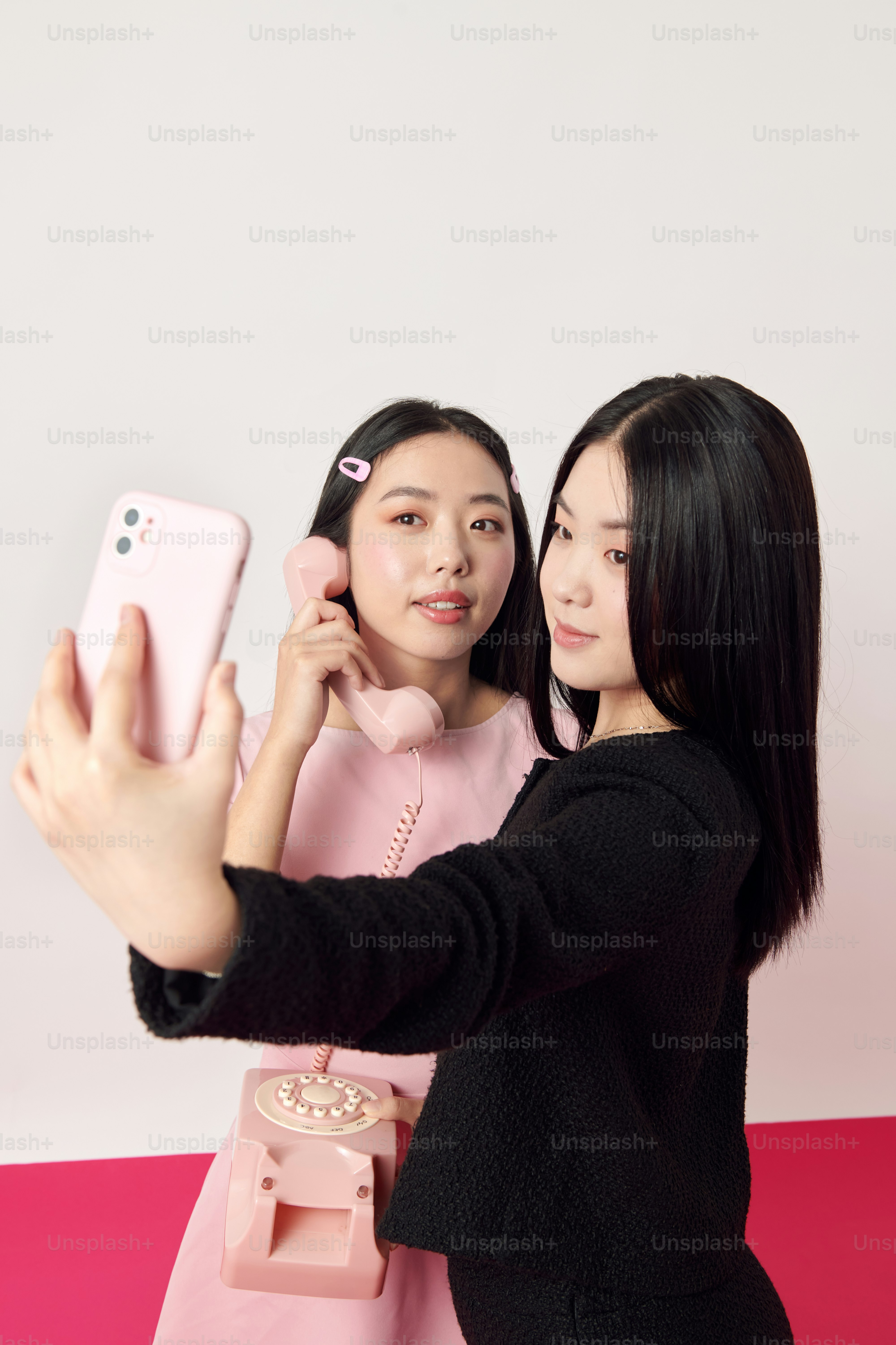 Dos mujeres asiáticas tomándose una foto con un celular