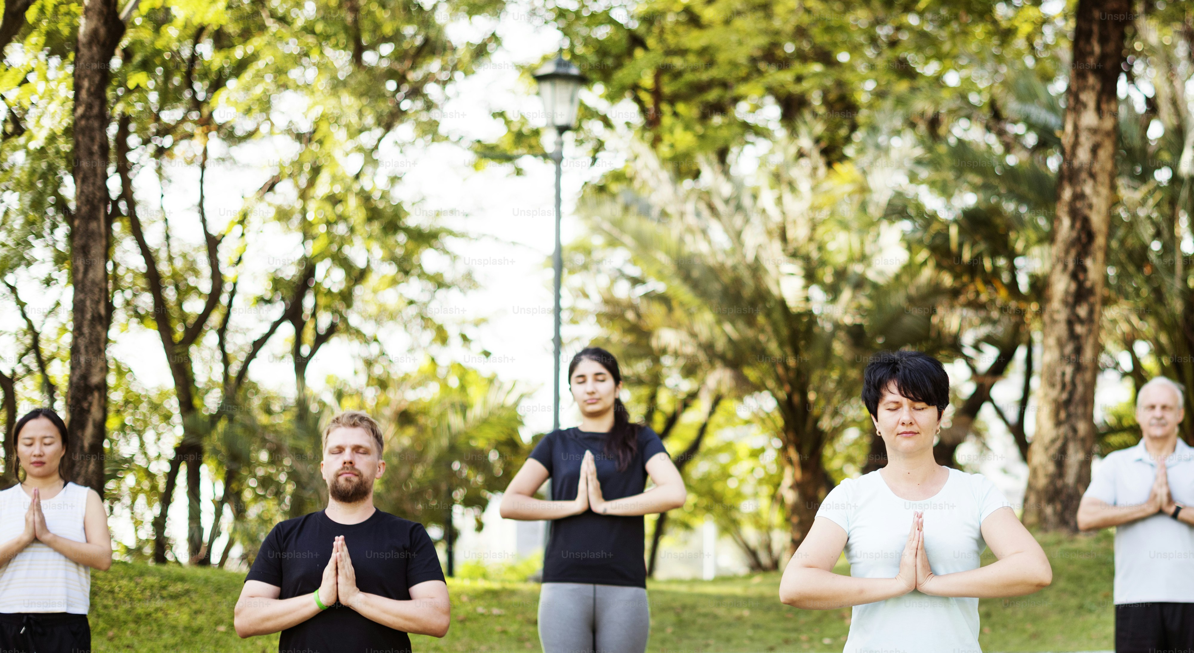 Persone che fanno yoga al parco