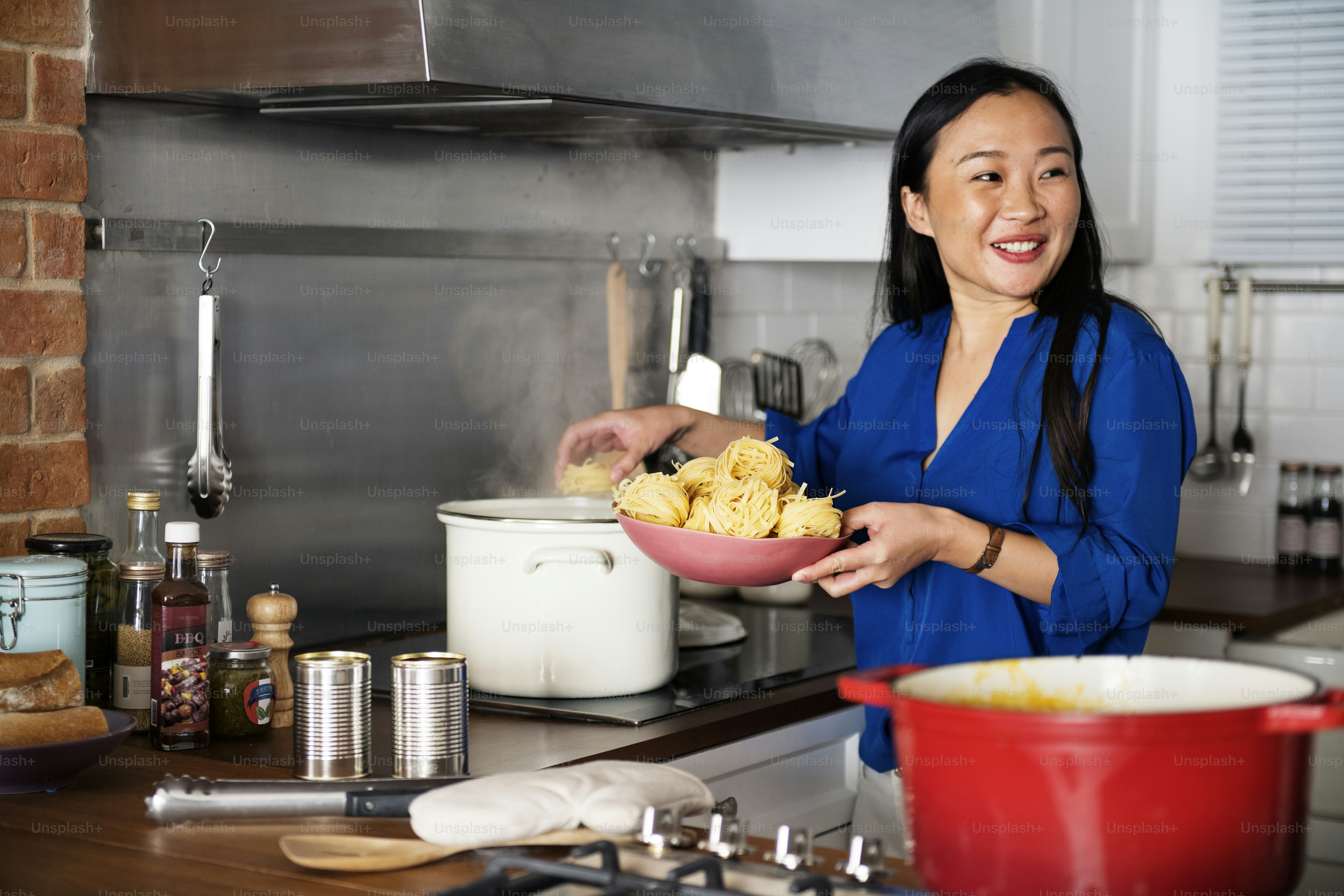 Donna asiatica che cucina la pasta in cucina