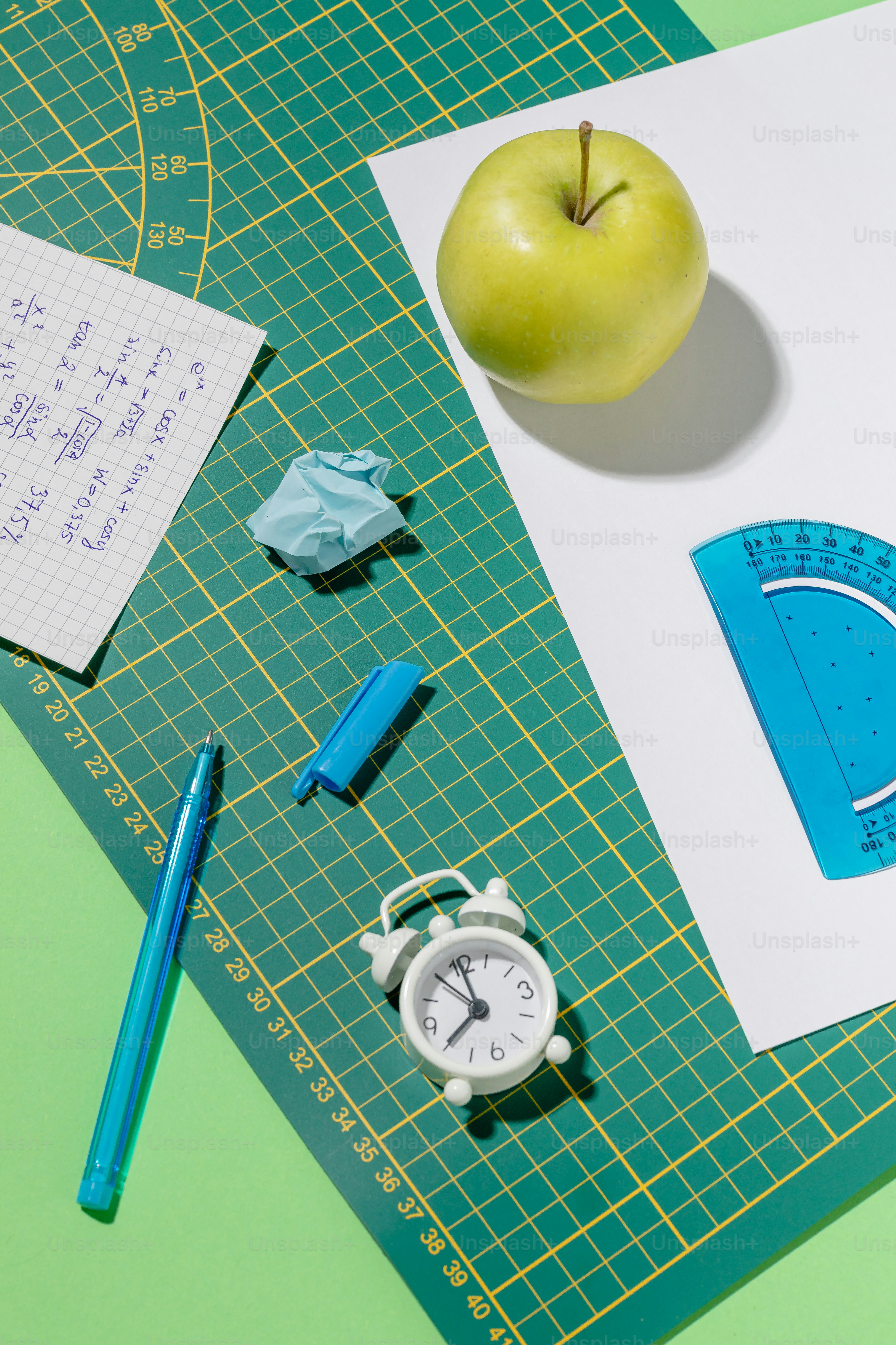 종이와 초록색 사과를 얹은 초록색 테이블
