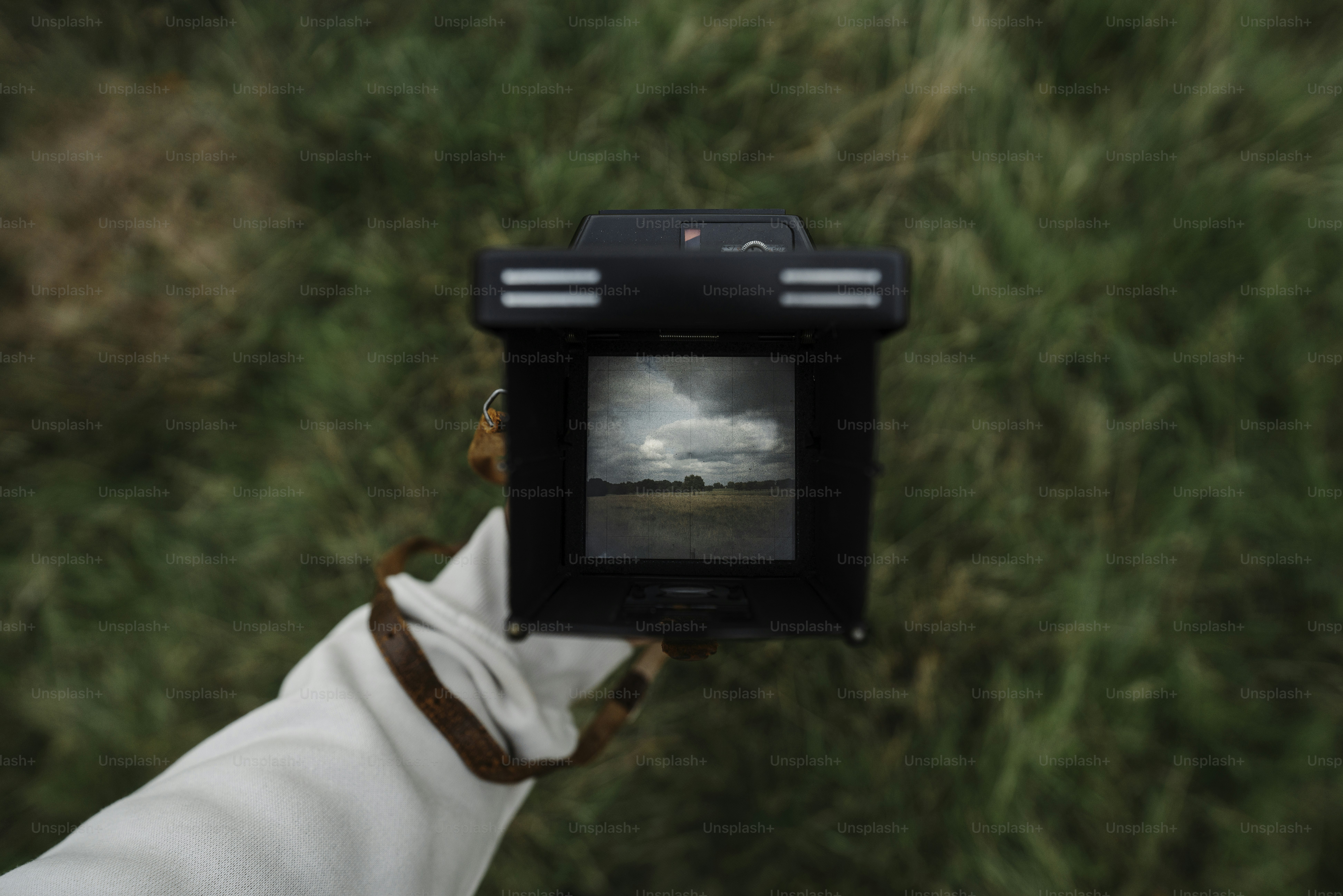 Una persona sosteniendo una pequeña cámara para tomar una foto