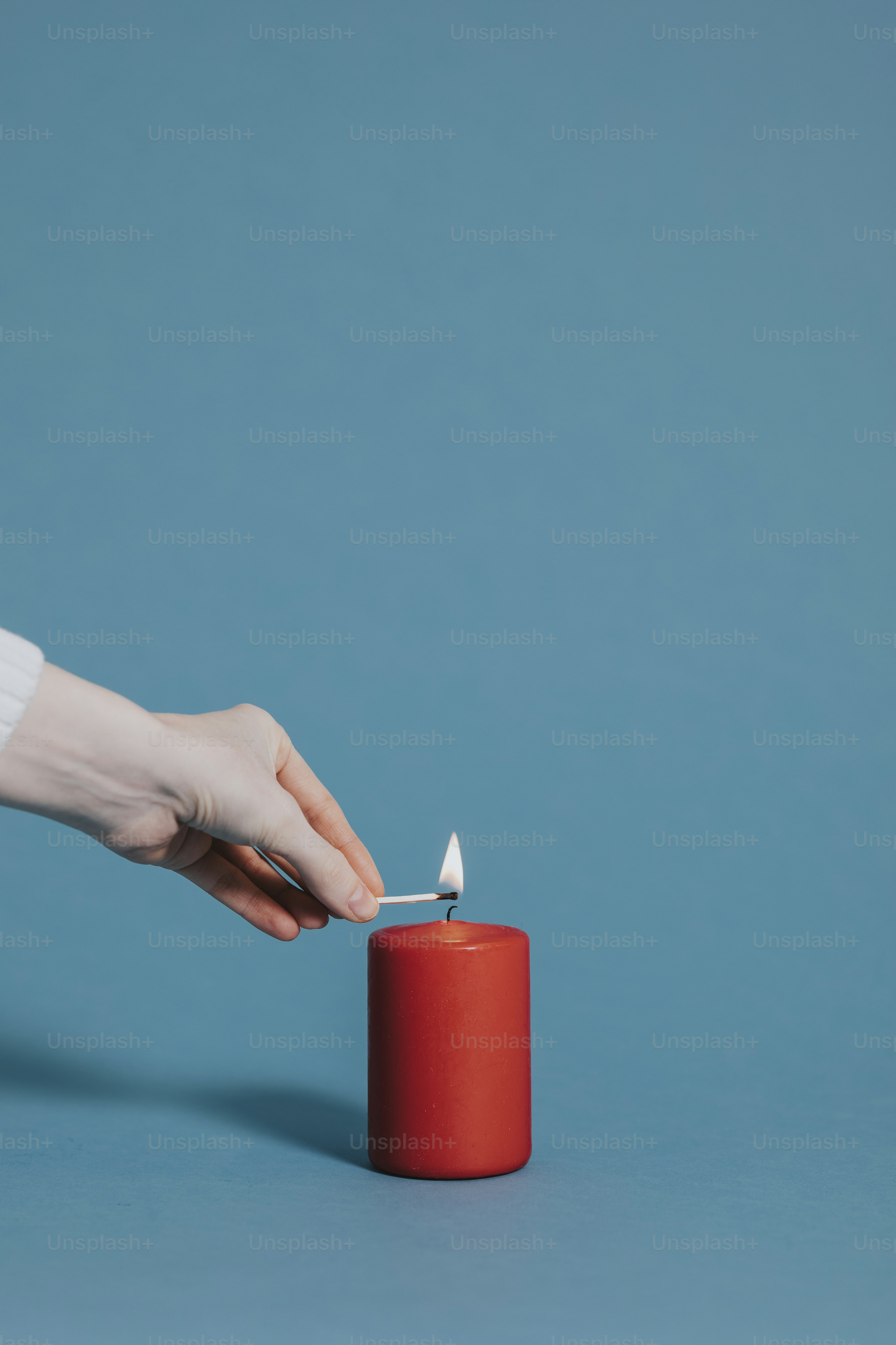 Woman lighting a red candle