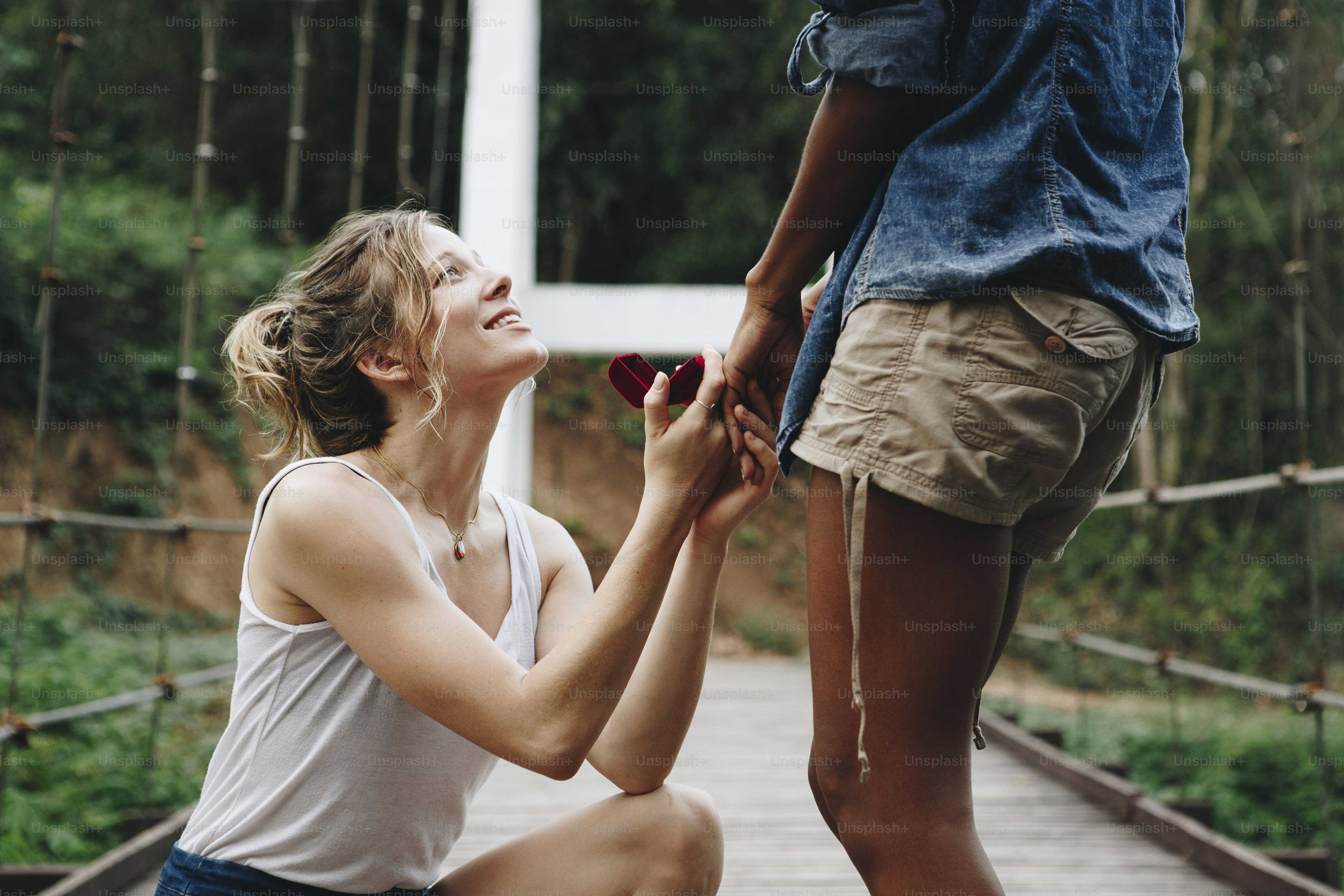 Woman proposing to her happy girlfriend outdoors love and marriage ...
