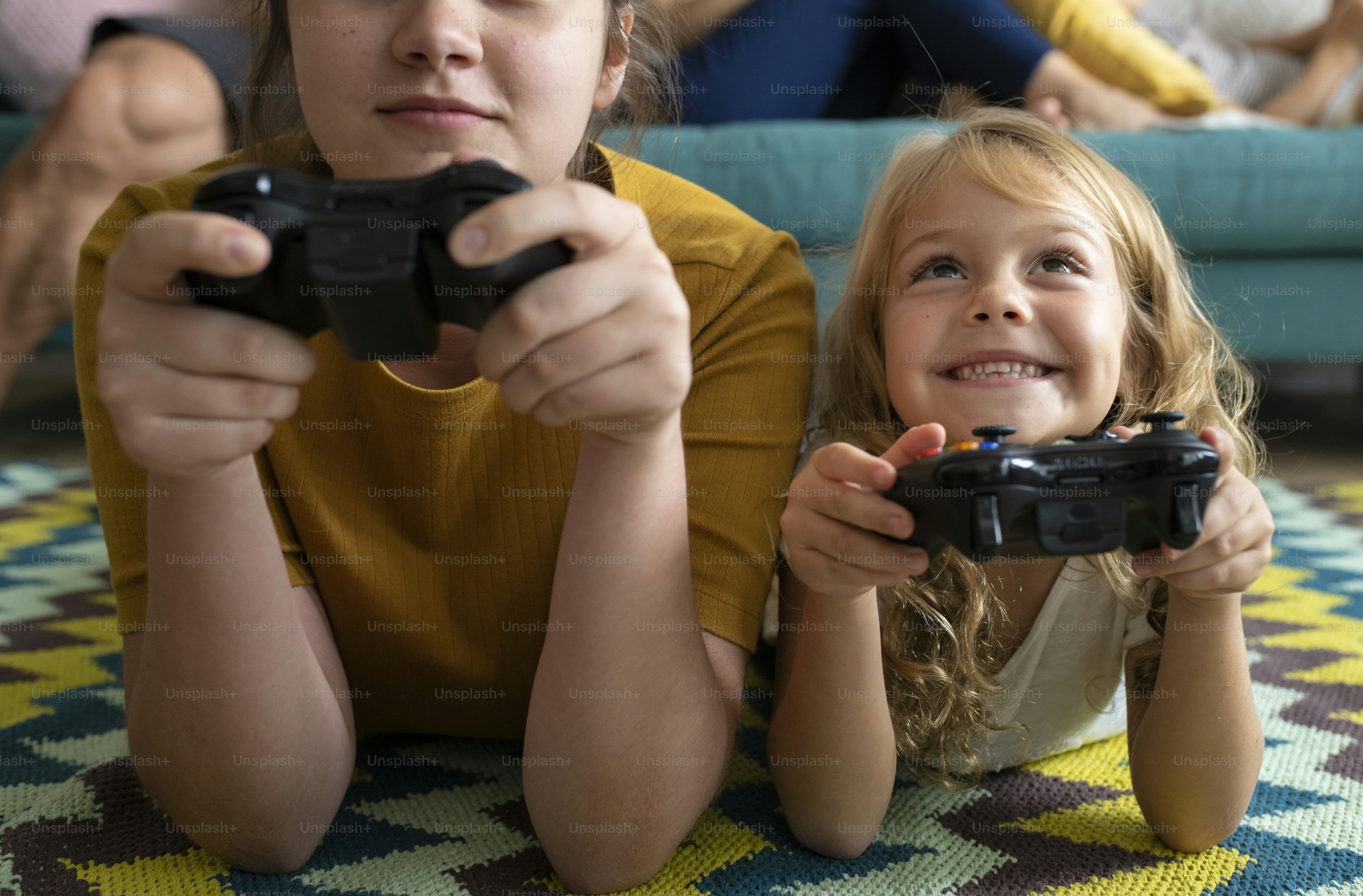 Sisters lying on the floor playing a video game