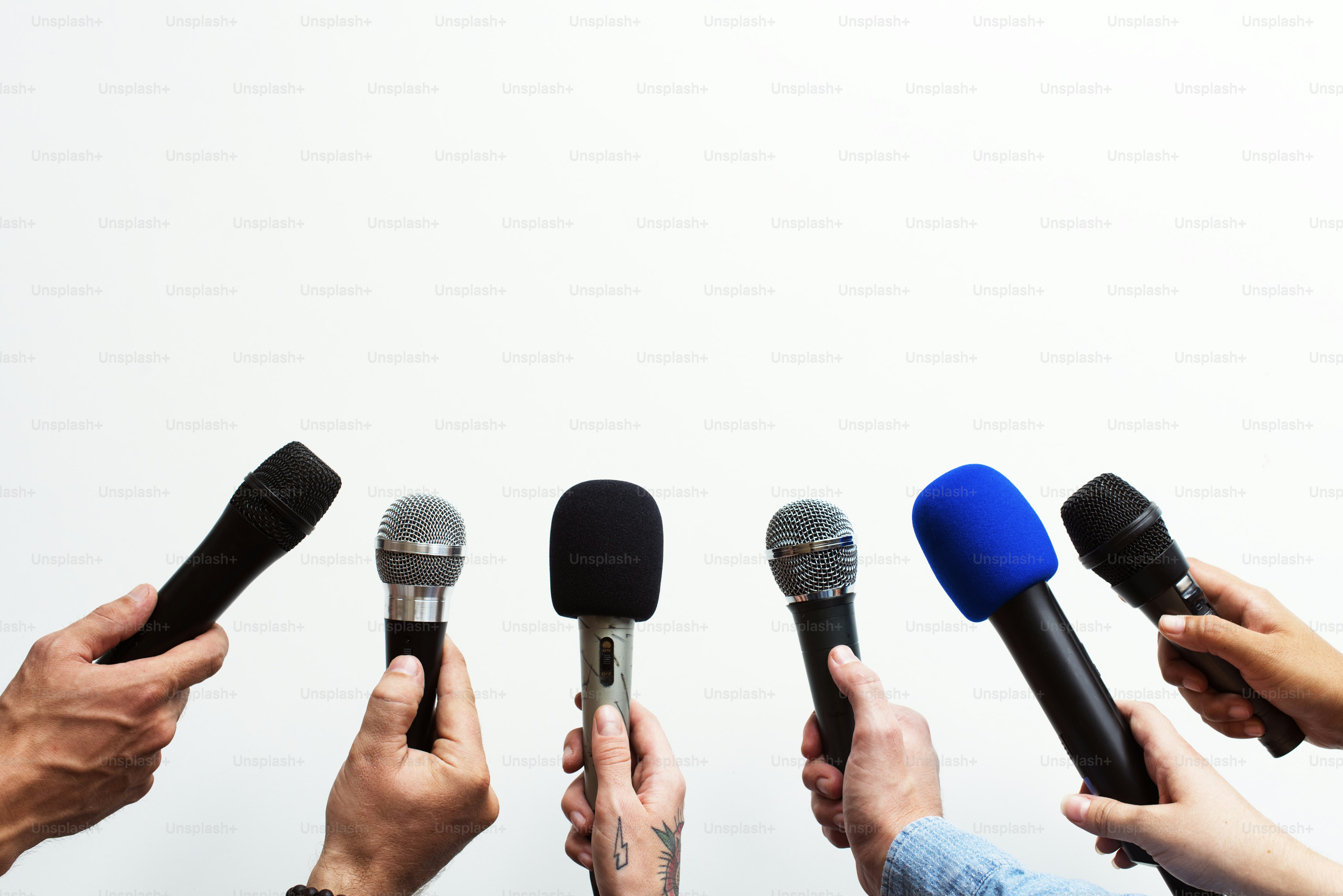 Les mains tenant le microphone pointent dans la même direction