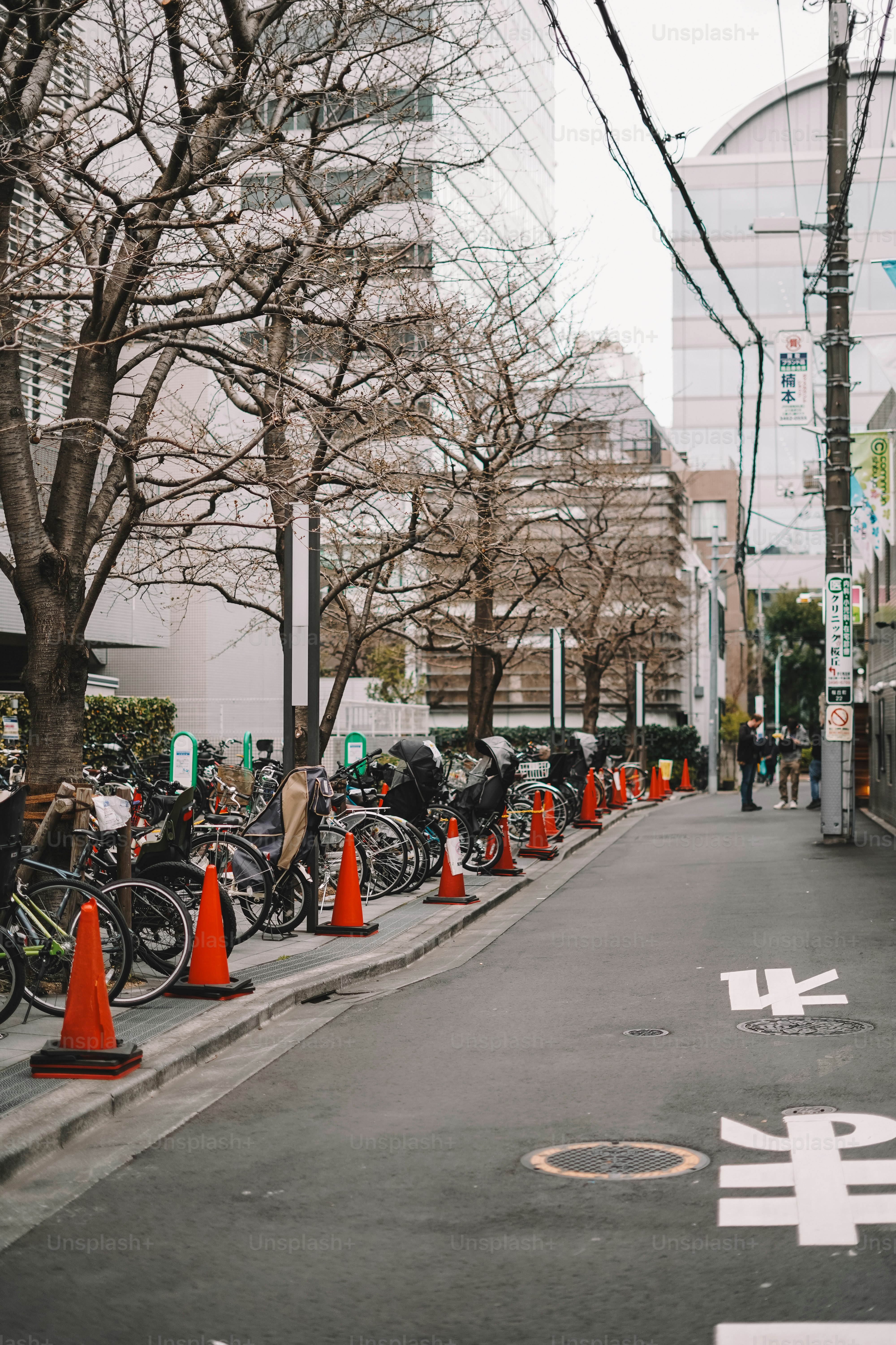 A city street lined with orange cones and bicycles
