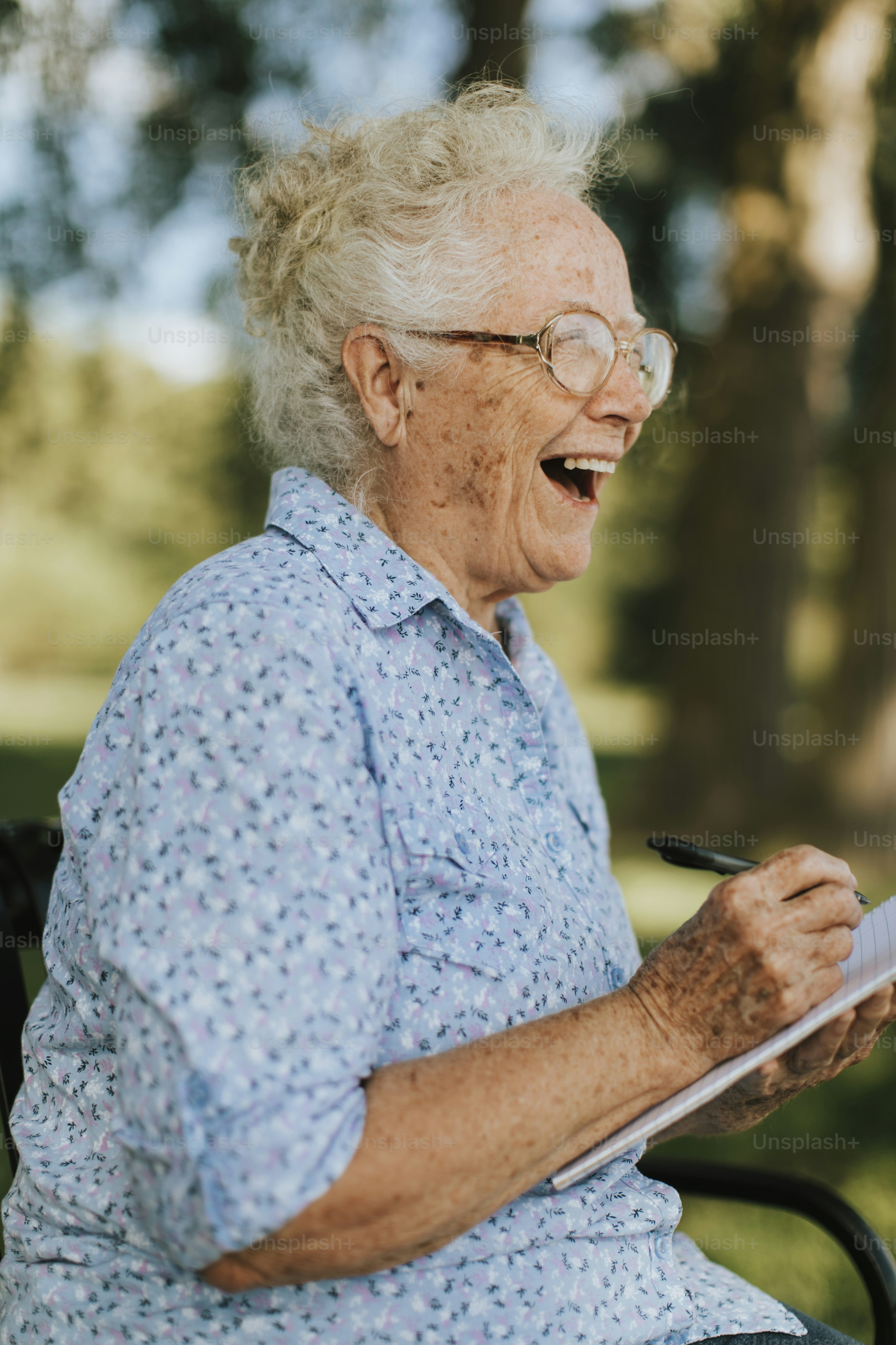 Senior woman writing down her memories into a notebook photo – Paper ...