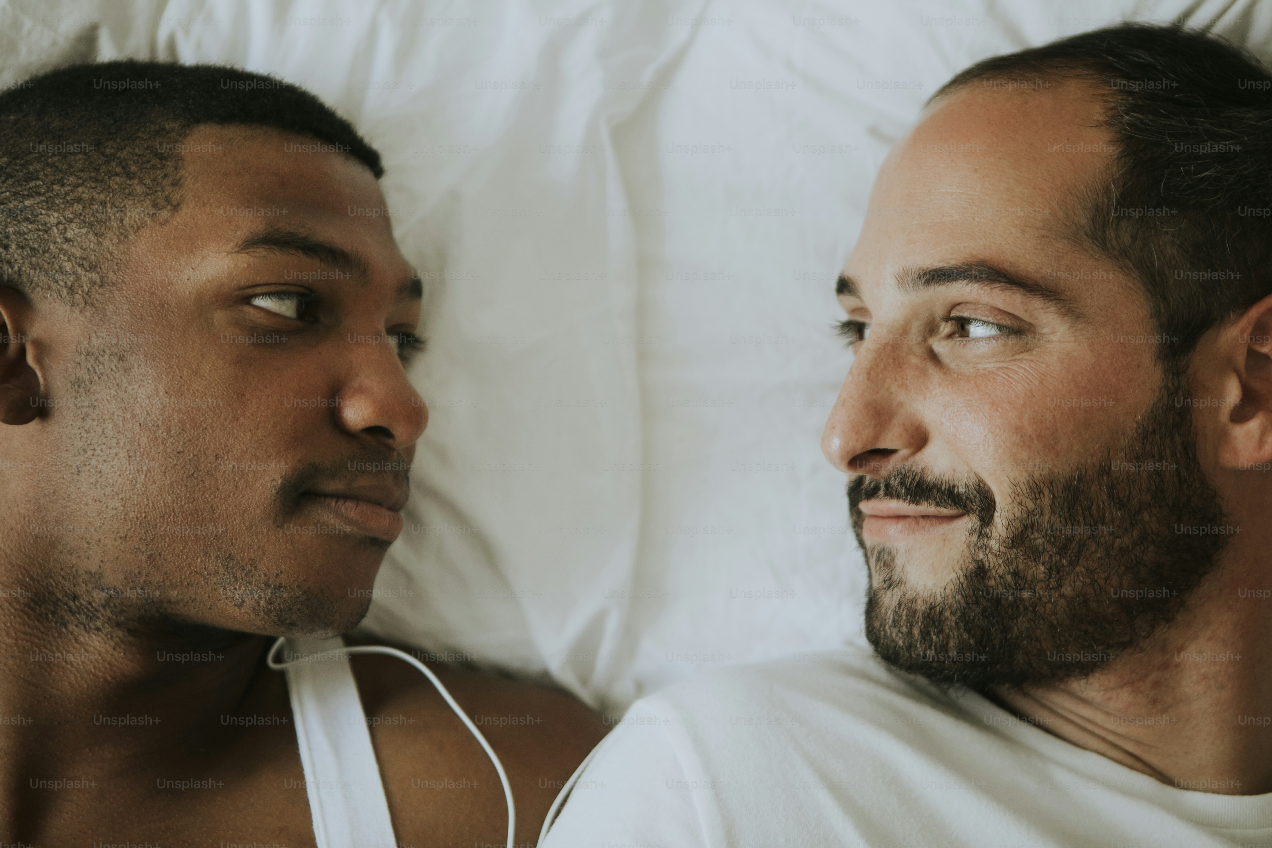 Gay couple cuddling in bed