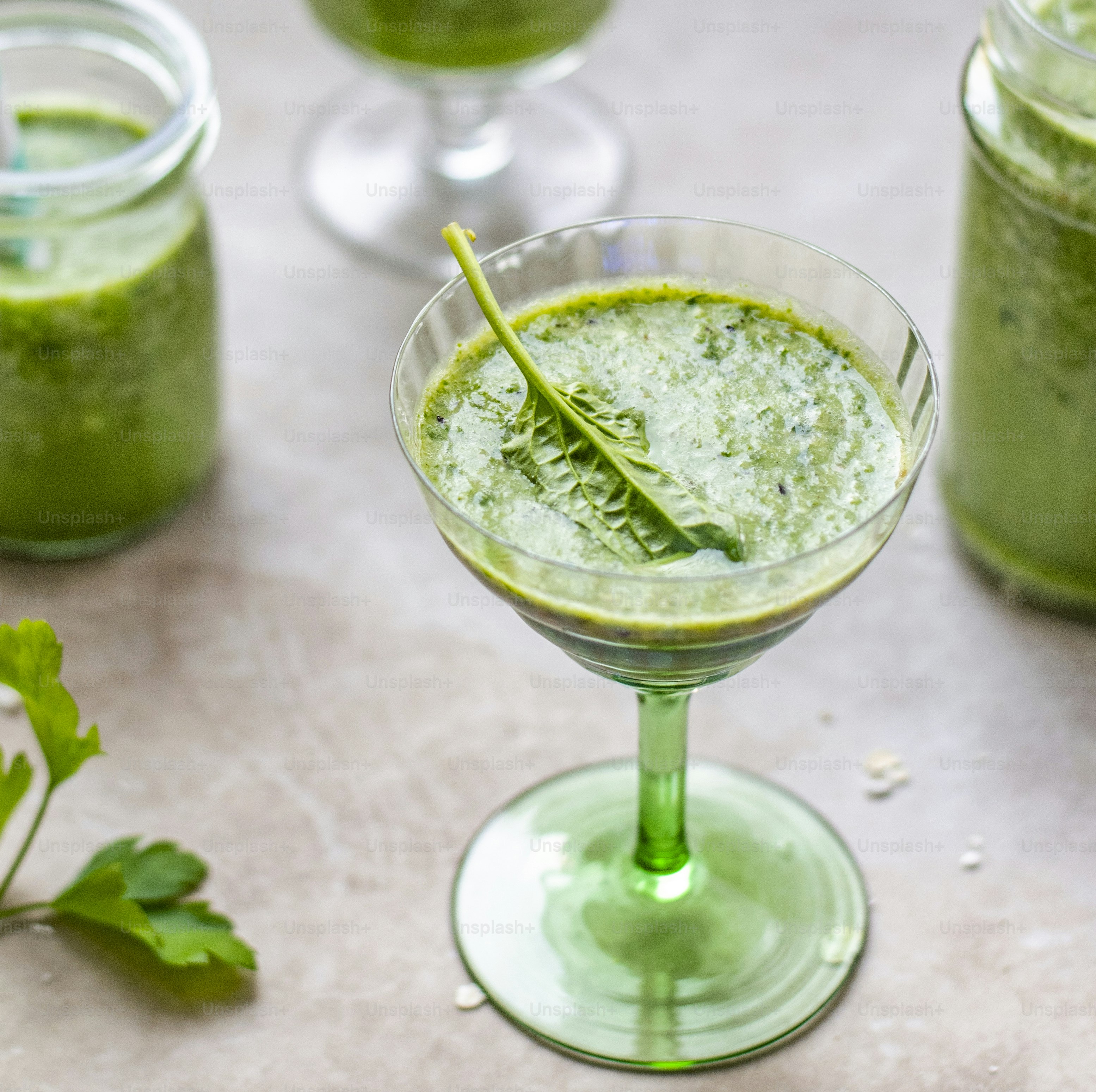 Smoothie vert décoré d’une feuille d’épinard dans un verre