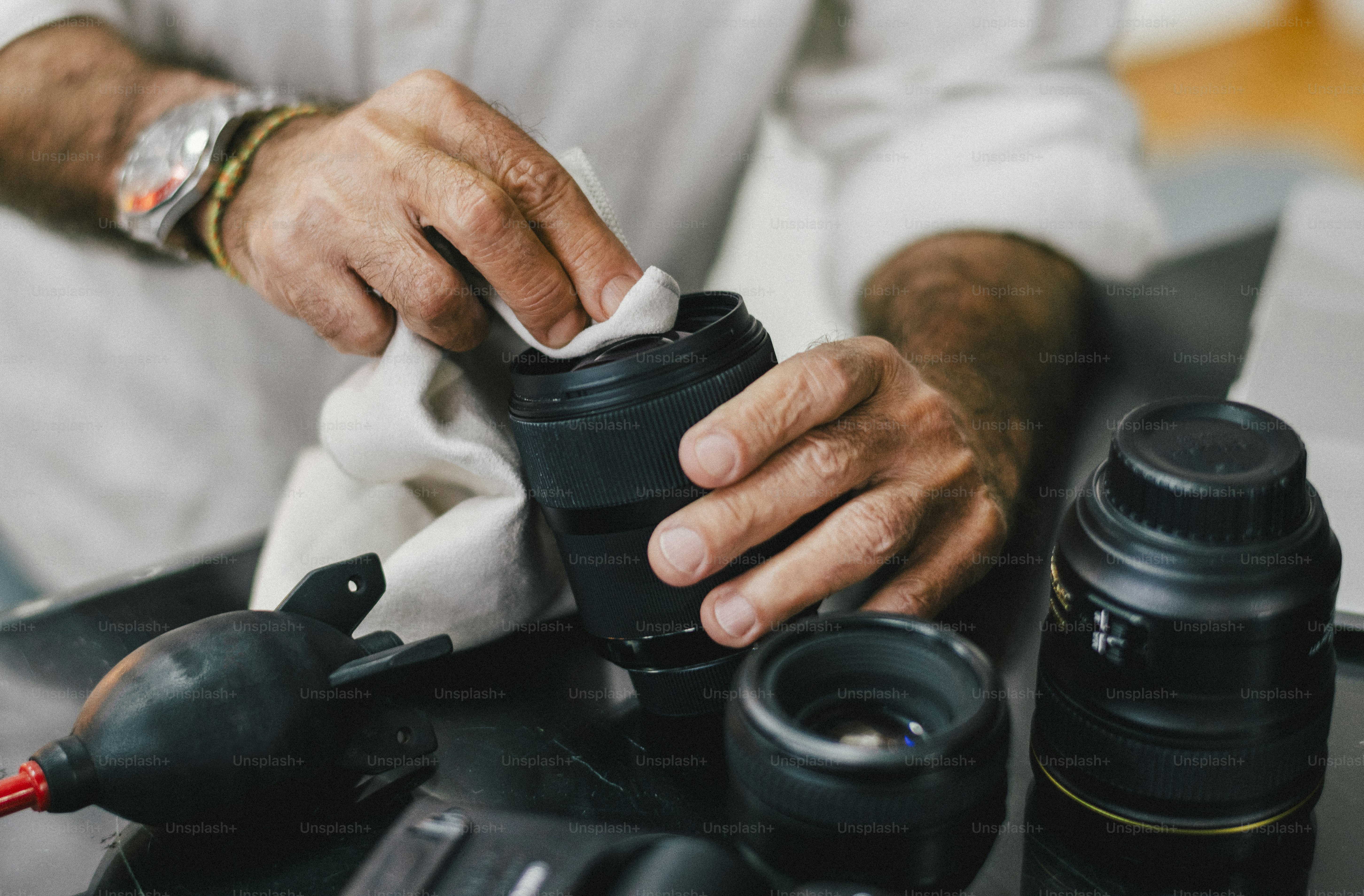 Senior photographer cleaning his lens