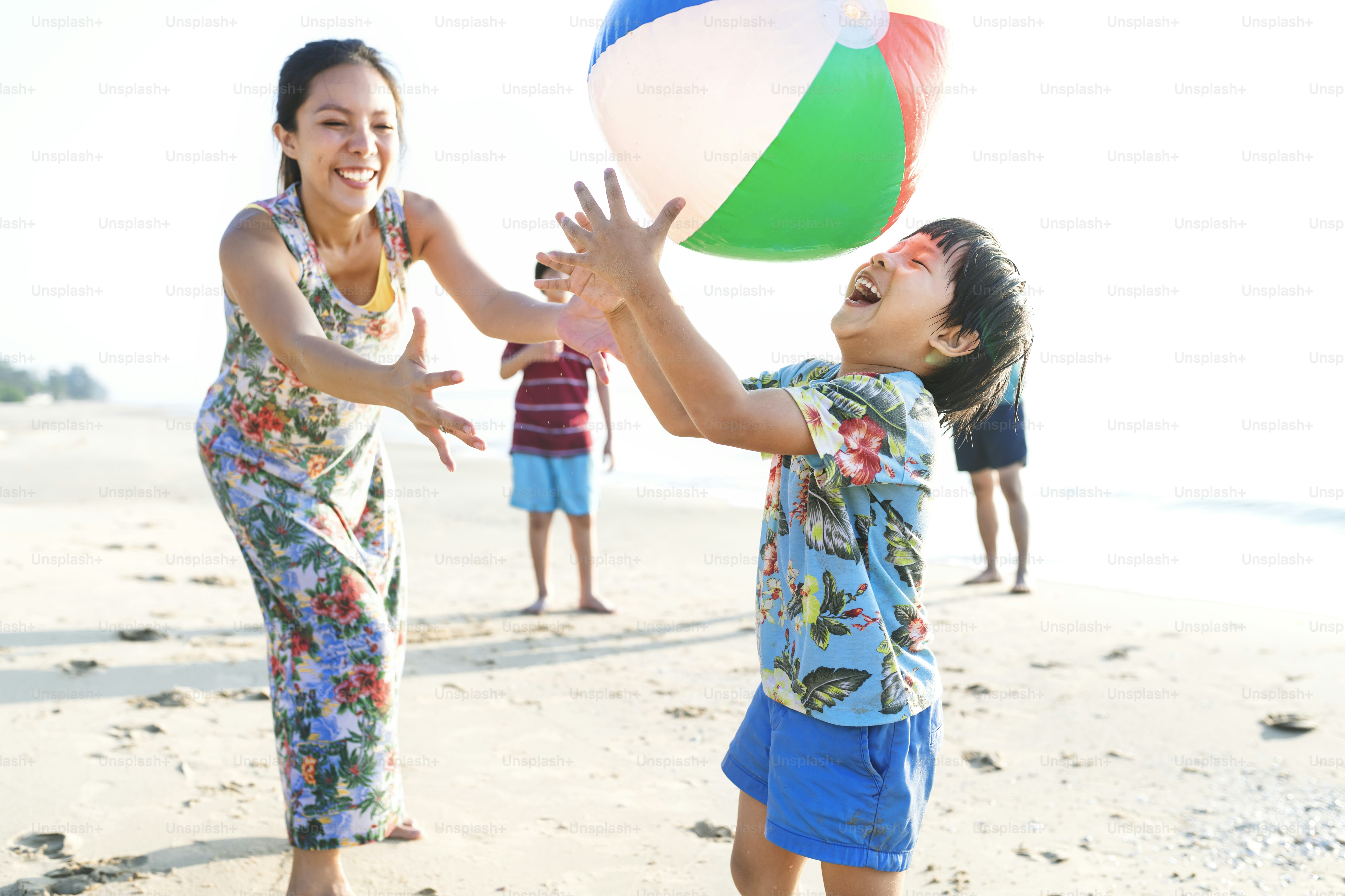 Família asiática que joga na praia