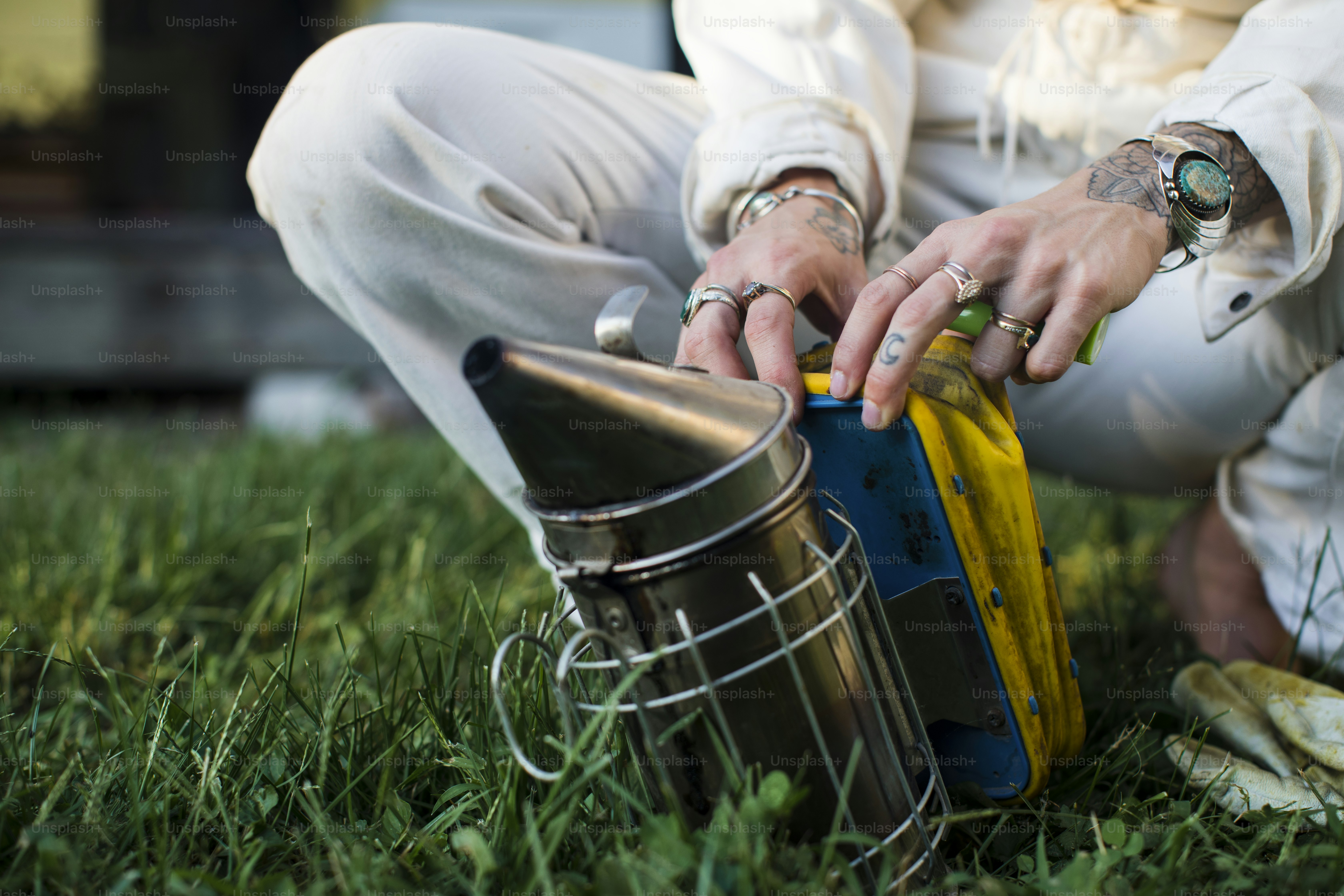 Apiculteur préparant l’enfumoir sur l’herbe