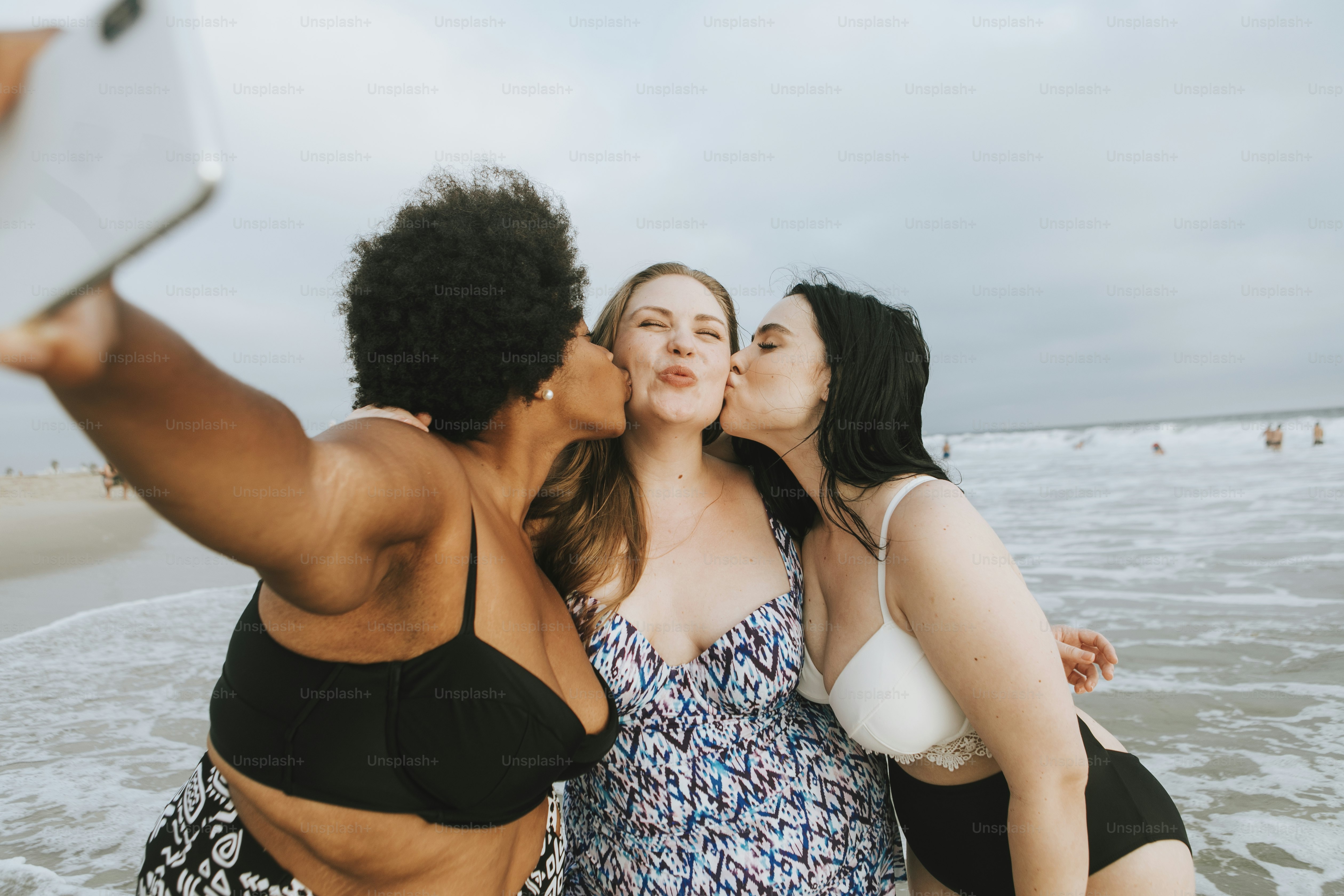 Beautiful curvy women taking a selfie at the beach