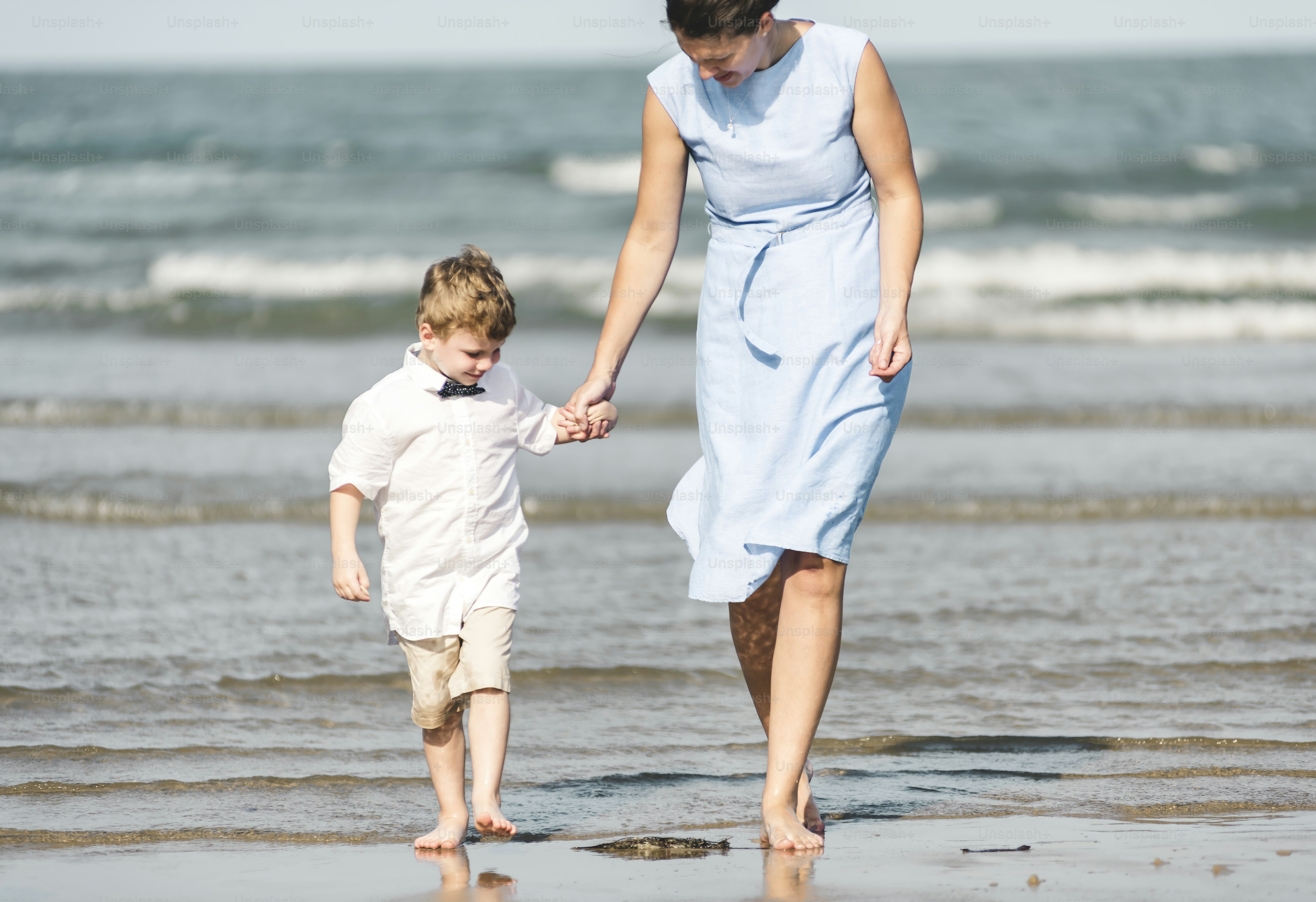 Ibu dan anak berjalan di pantai