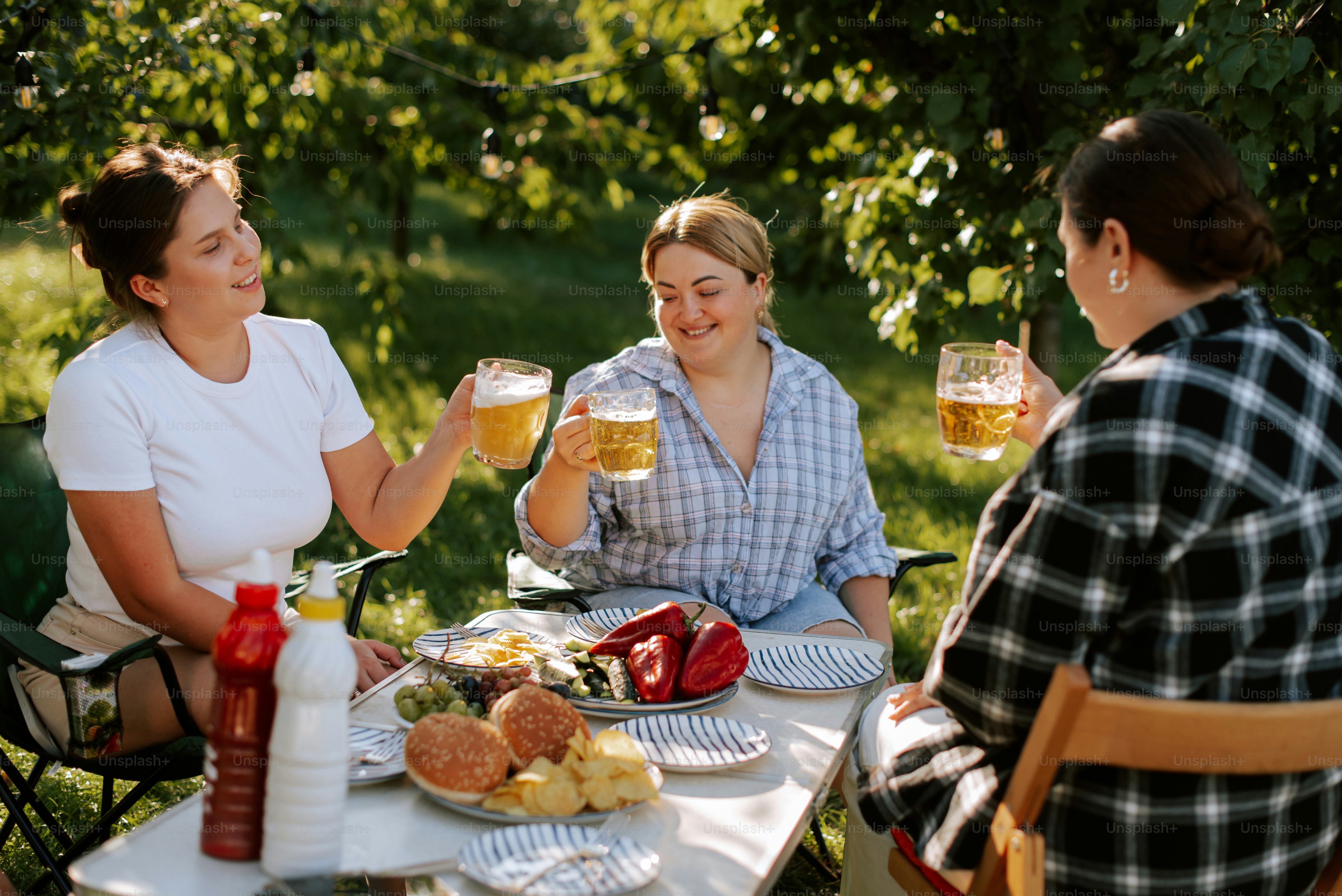 A group of people sitting around a table with food and drinks photo ...