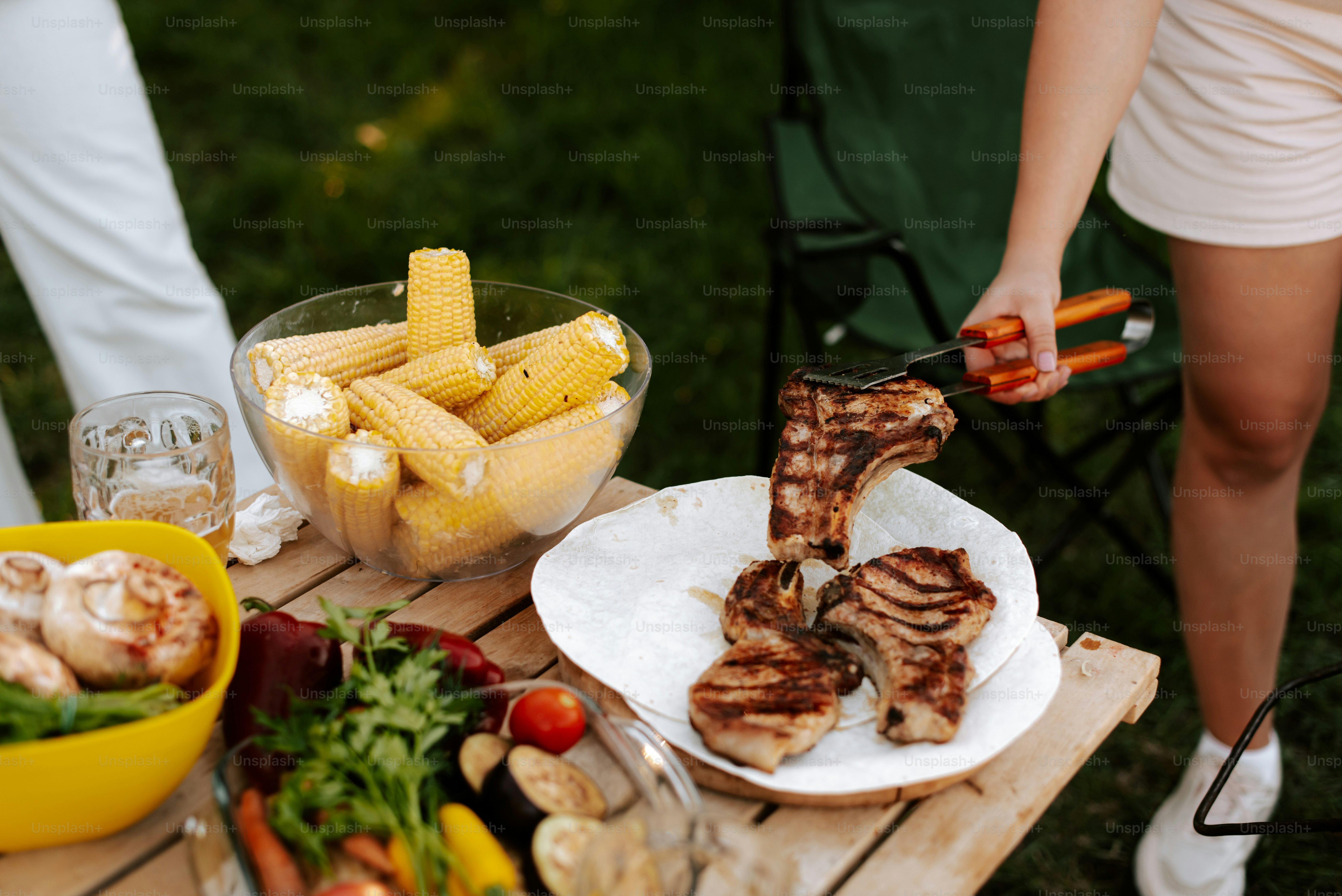 A table topped with plates of food and a bowl of vegetables