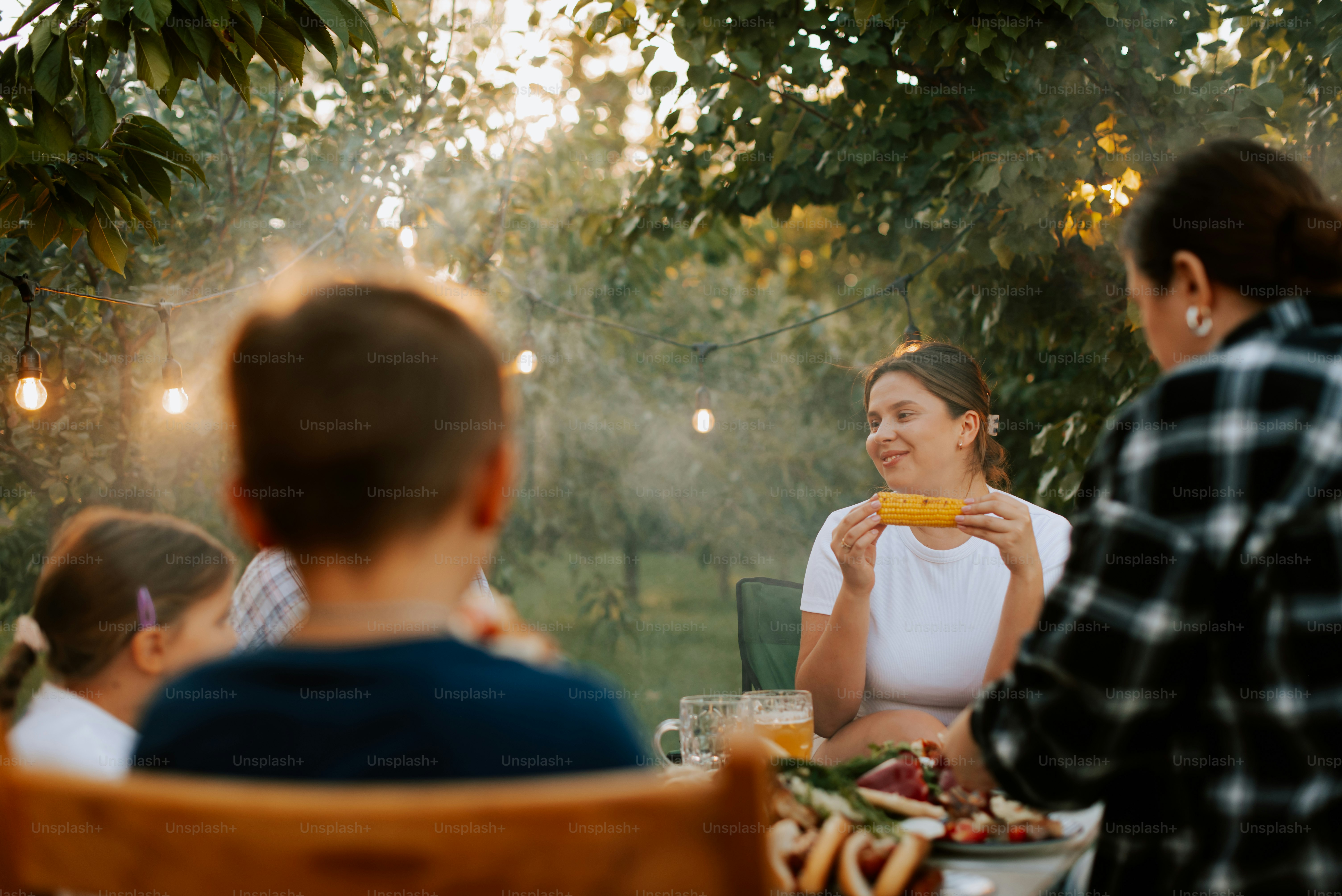A group of people sitting around a table with food