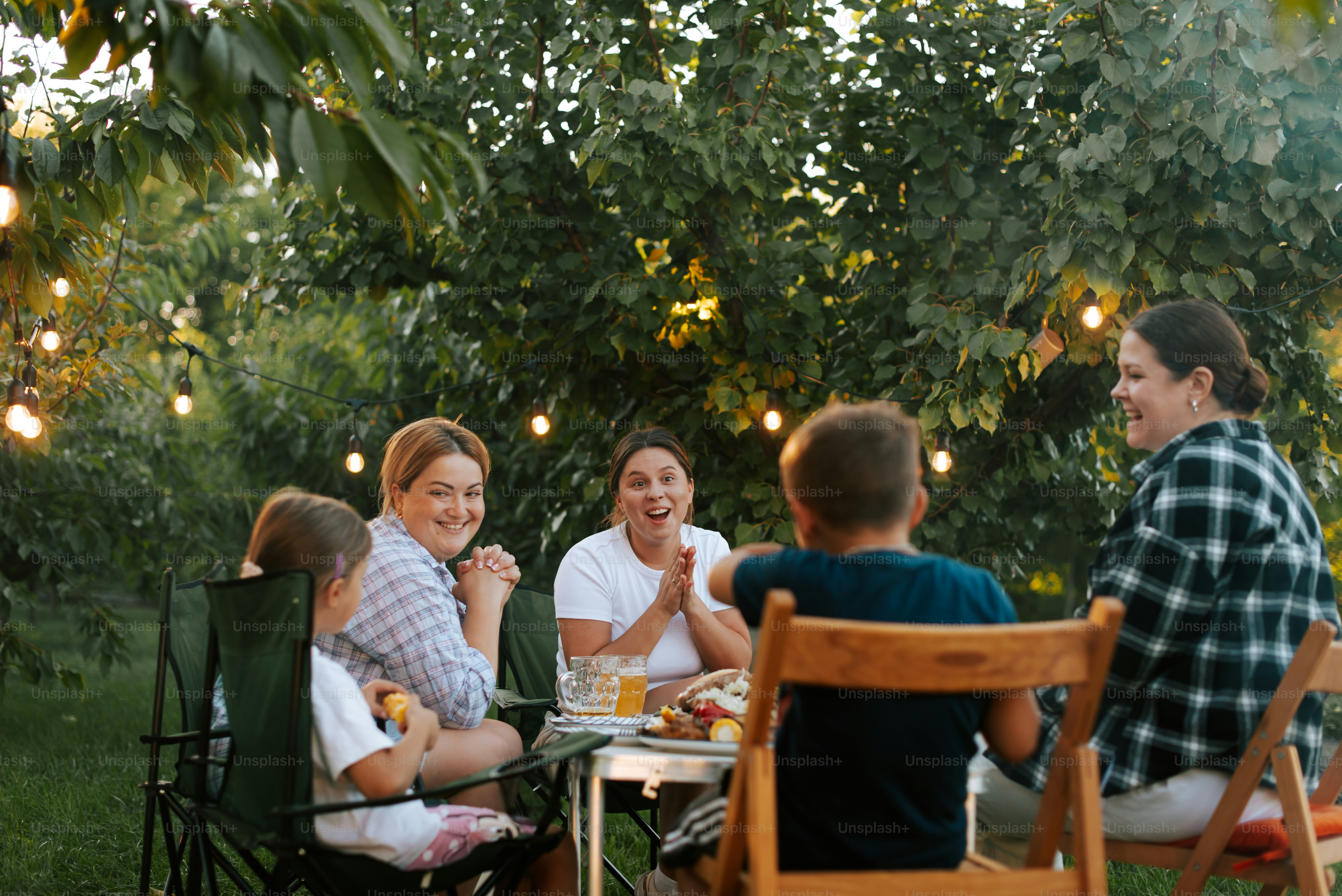 A group of people sitting around a table outside