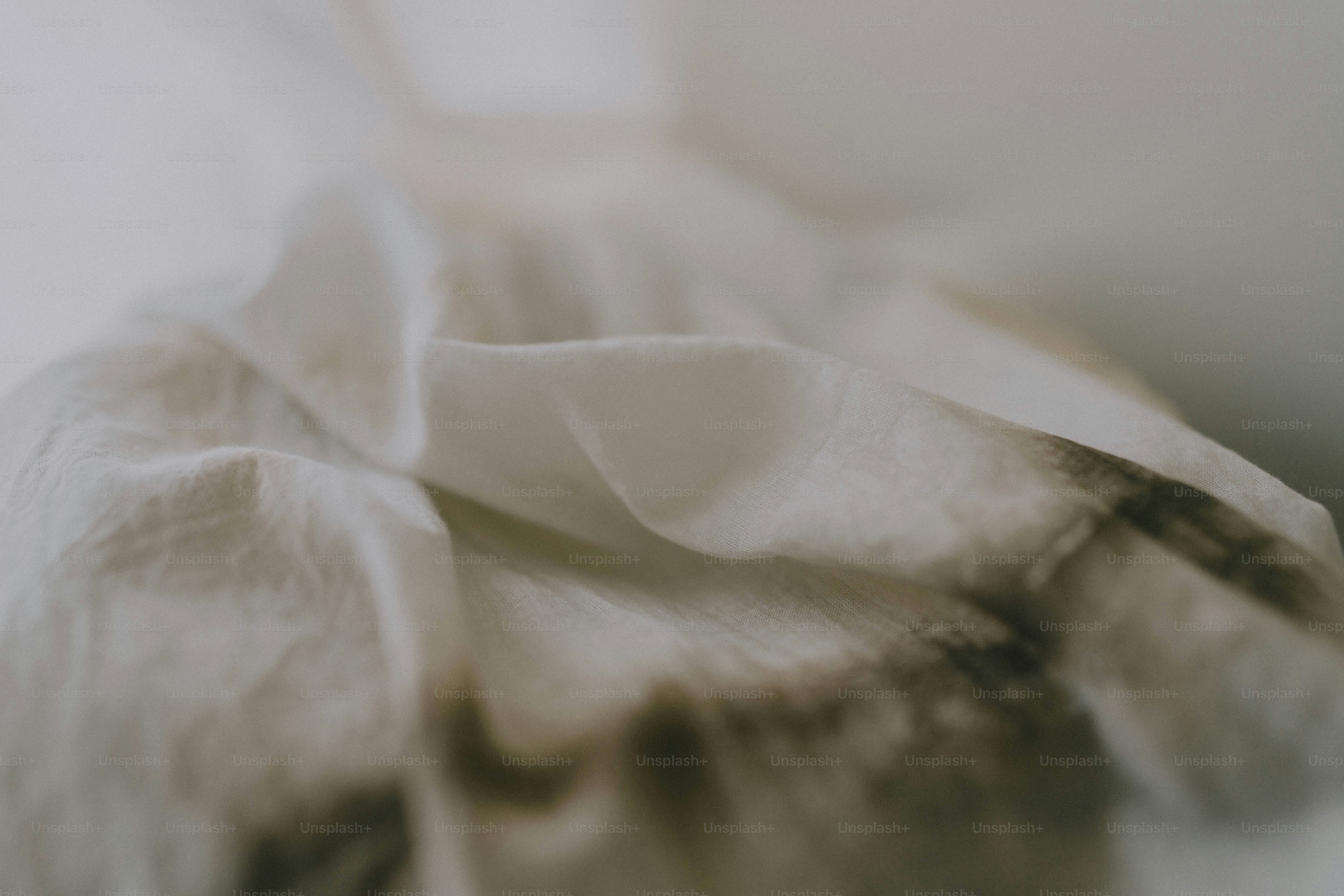 A blurry photo of a white sheet on a bed
