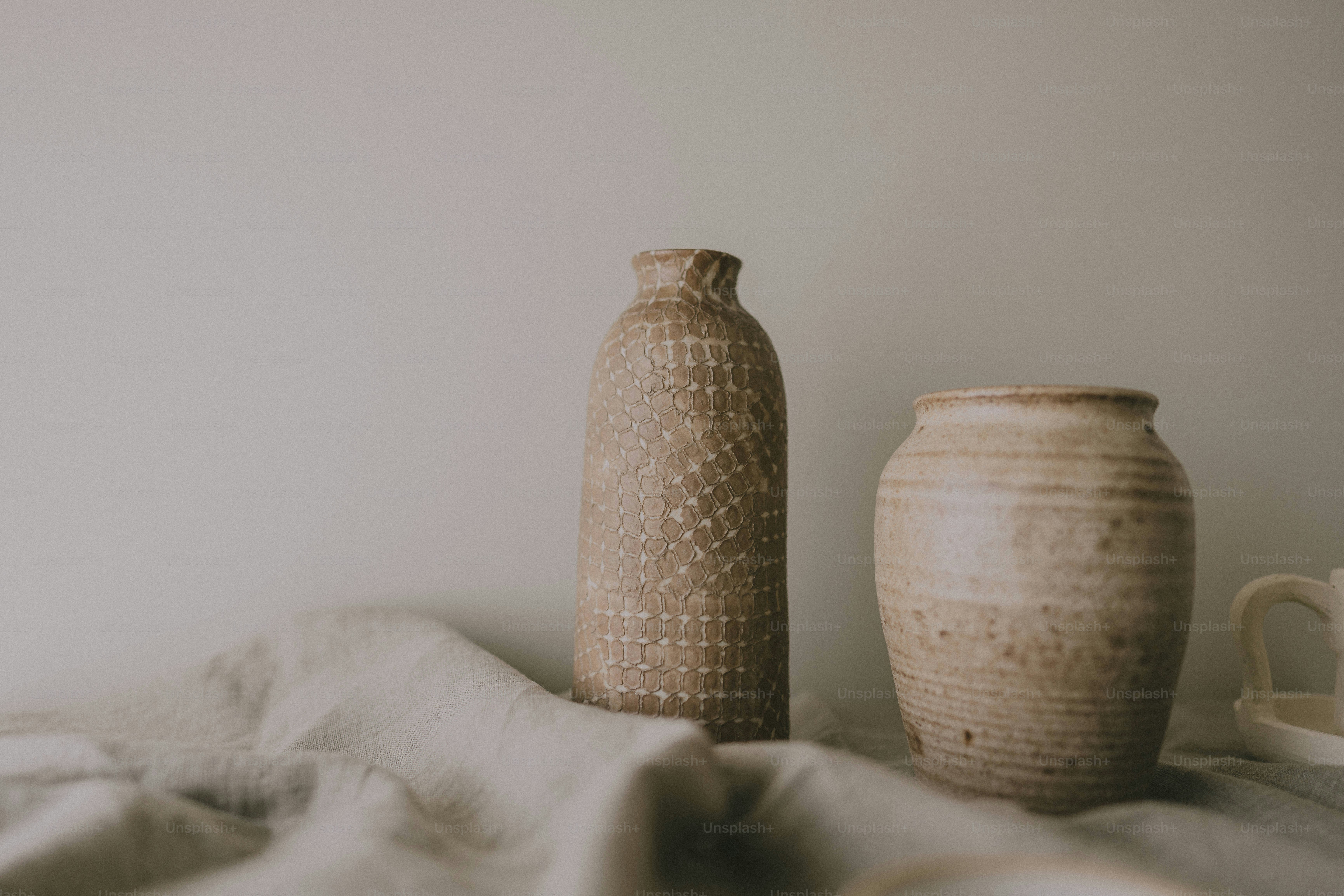 A couple of vases sitting on top of a bed