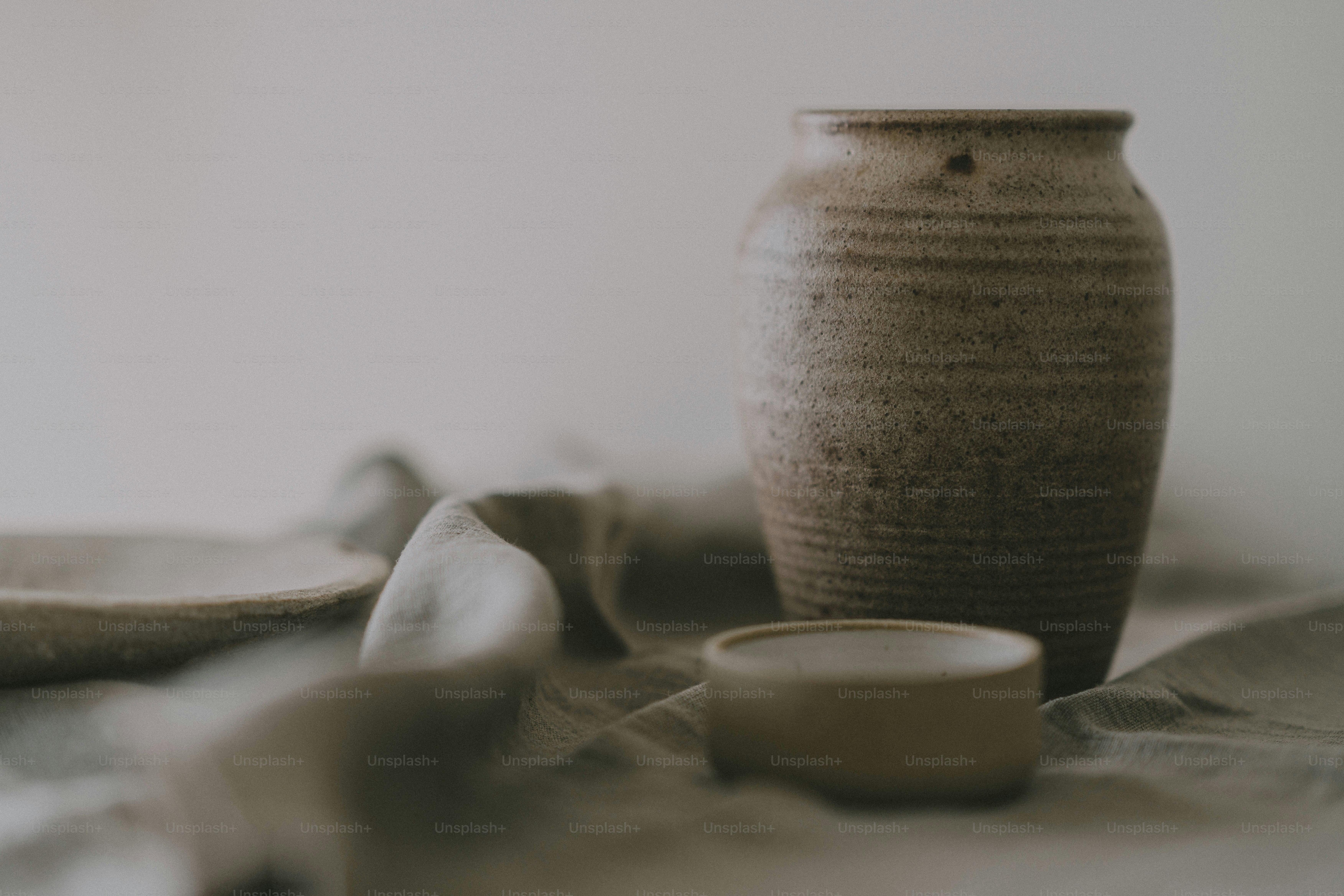 A vase sitting on top of a bed next to a pillow