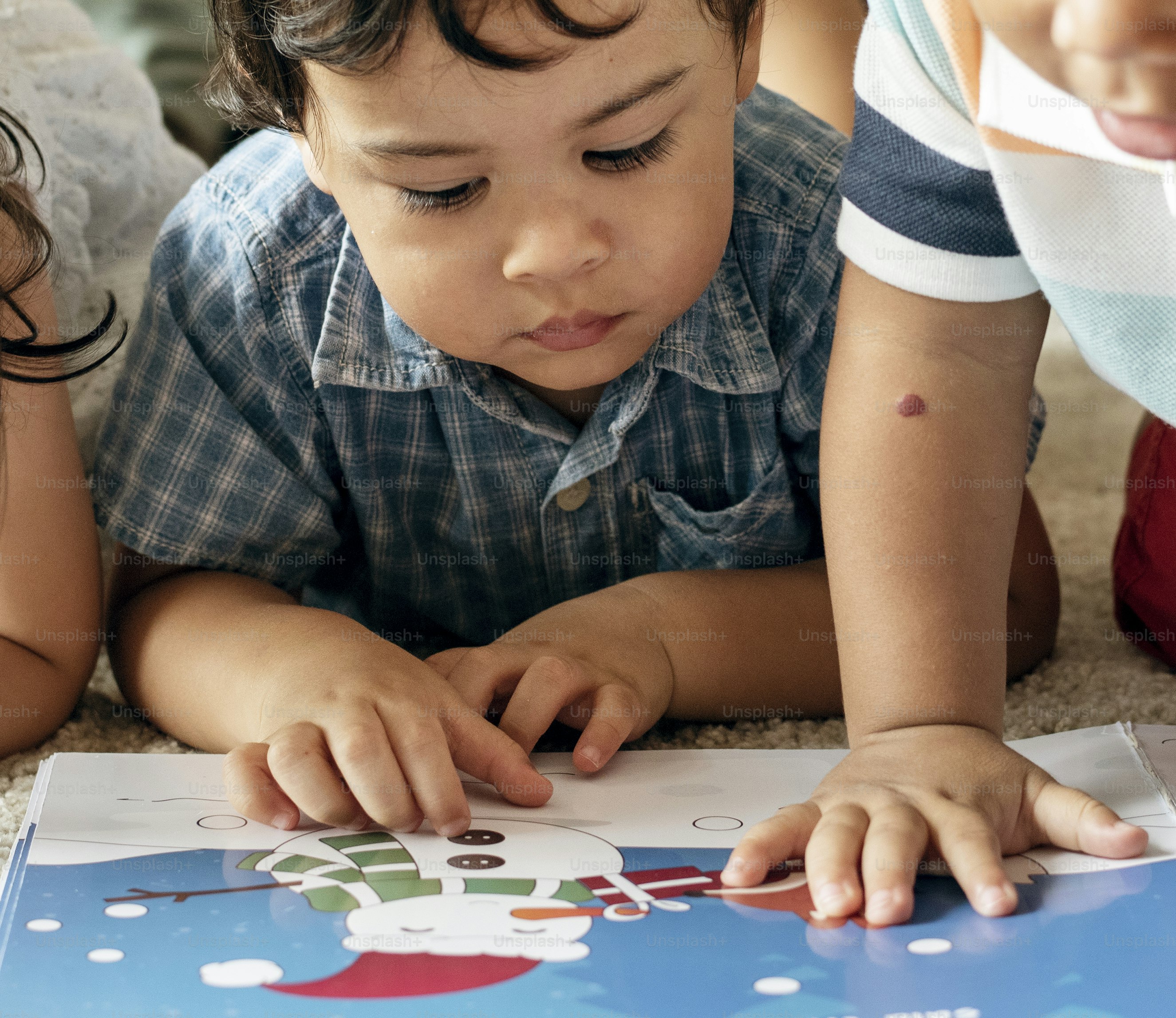 Children reading a book on the floor
