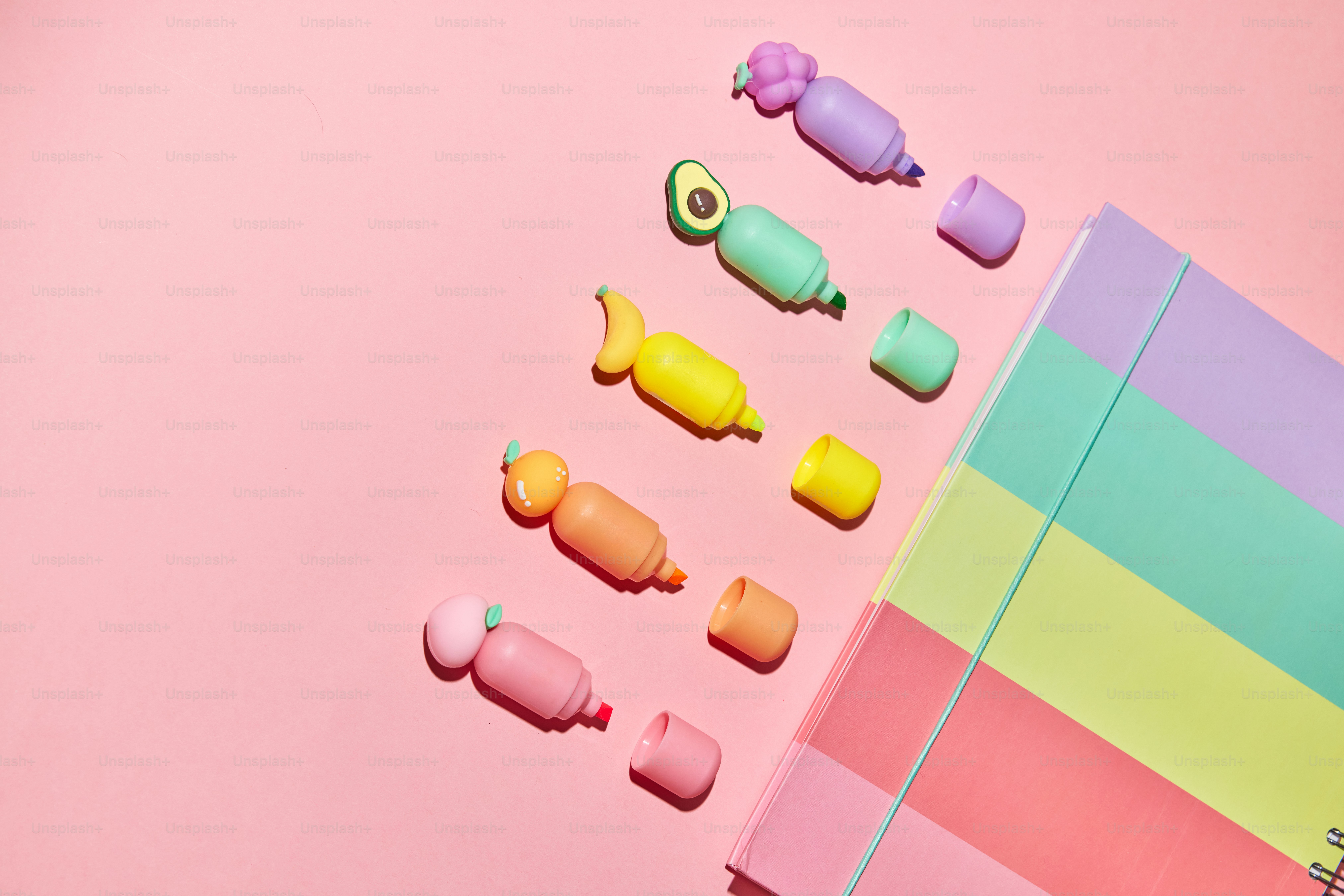 A bunch of different colored candies on a pink surface