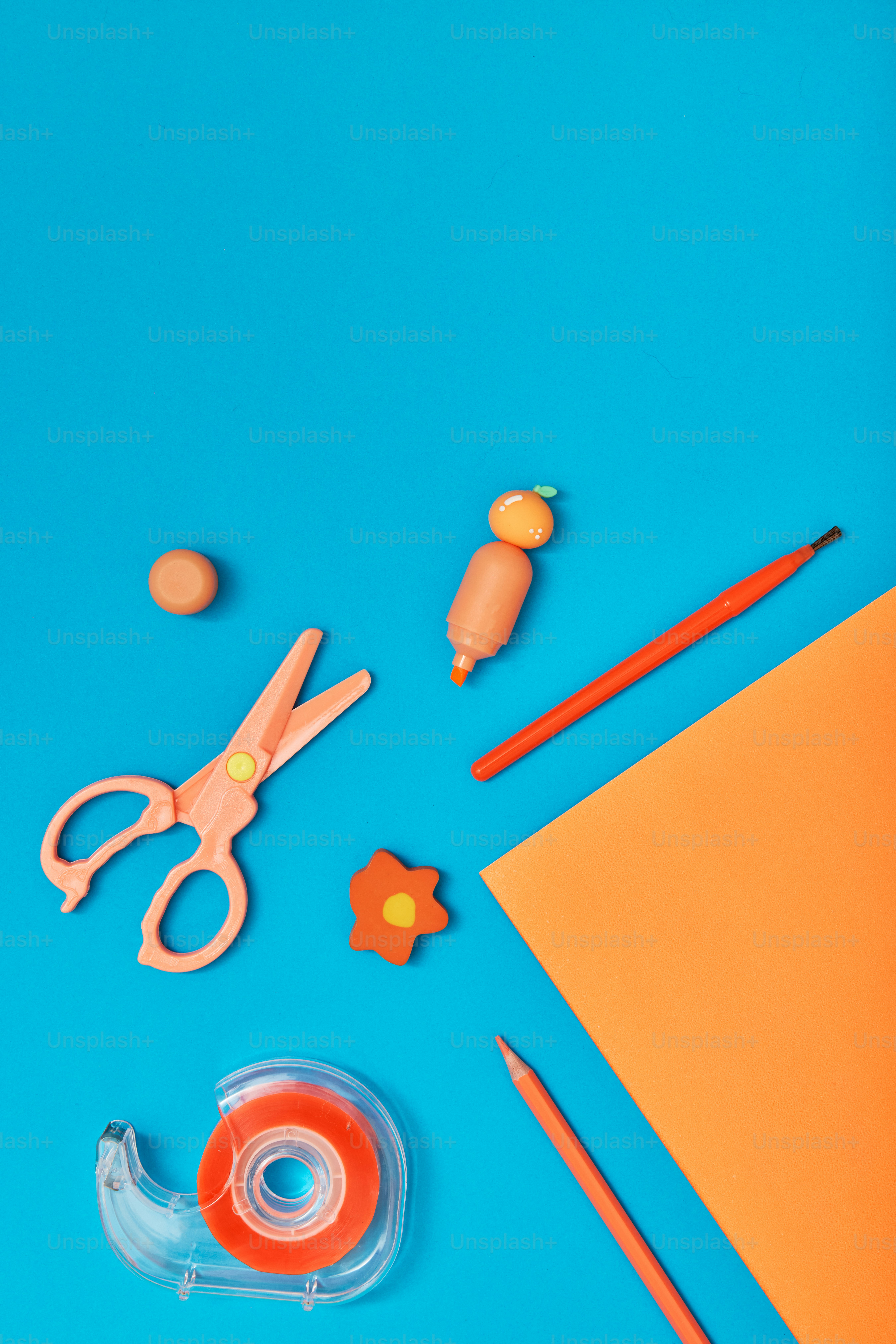 A pair of scissors, tape, scissors, and other items on a blue background