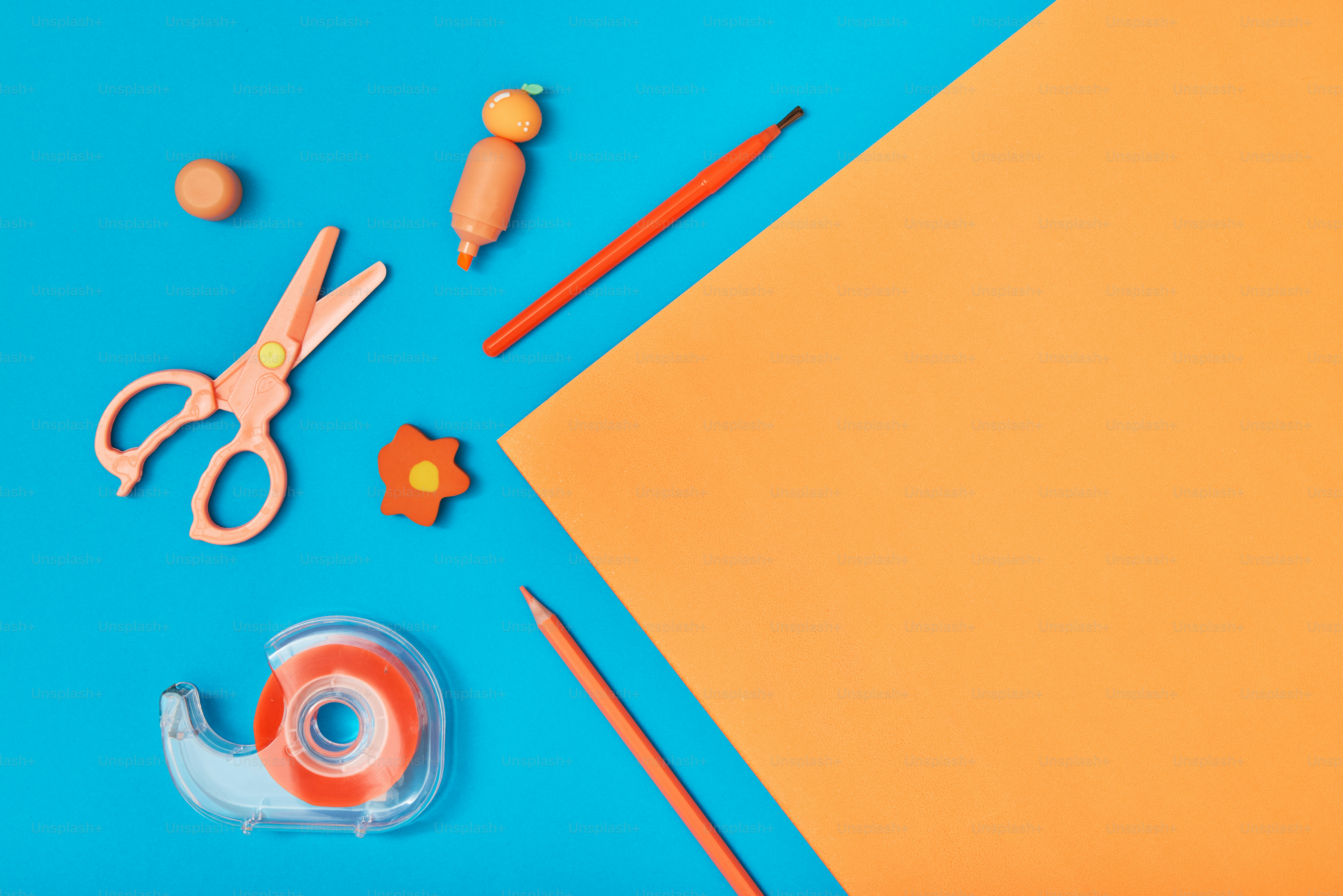 A pair of scissors, tape, scissors, and other items on a blue and