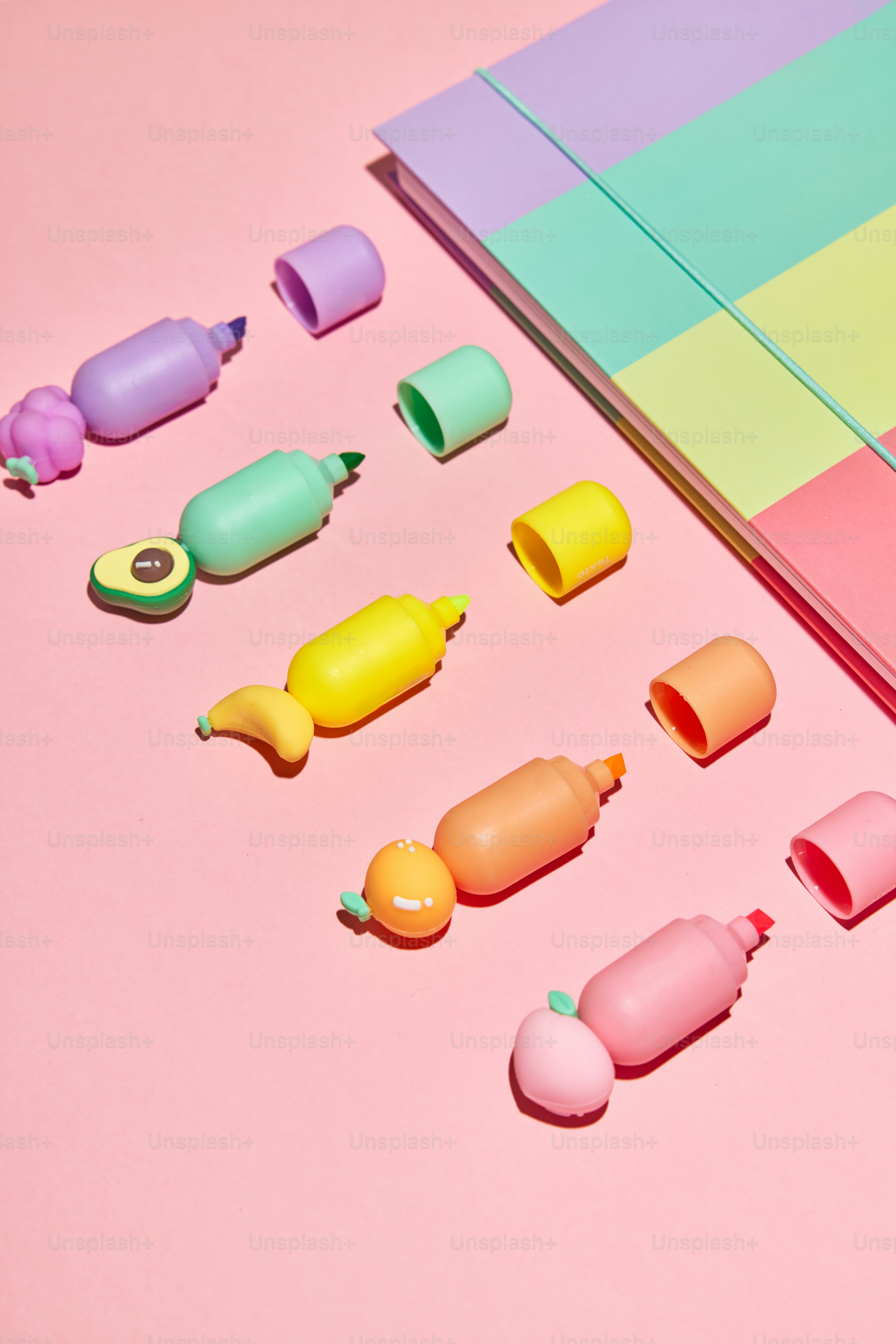 A bunch of different colored candies on a pink surface