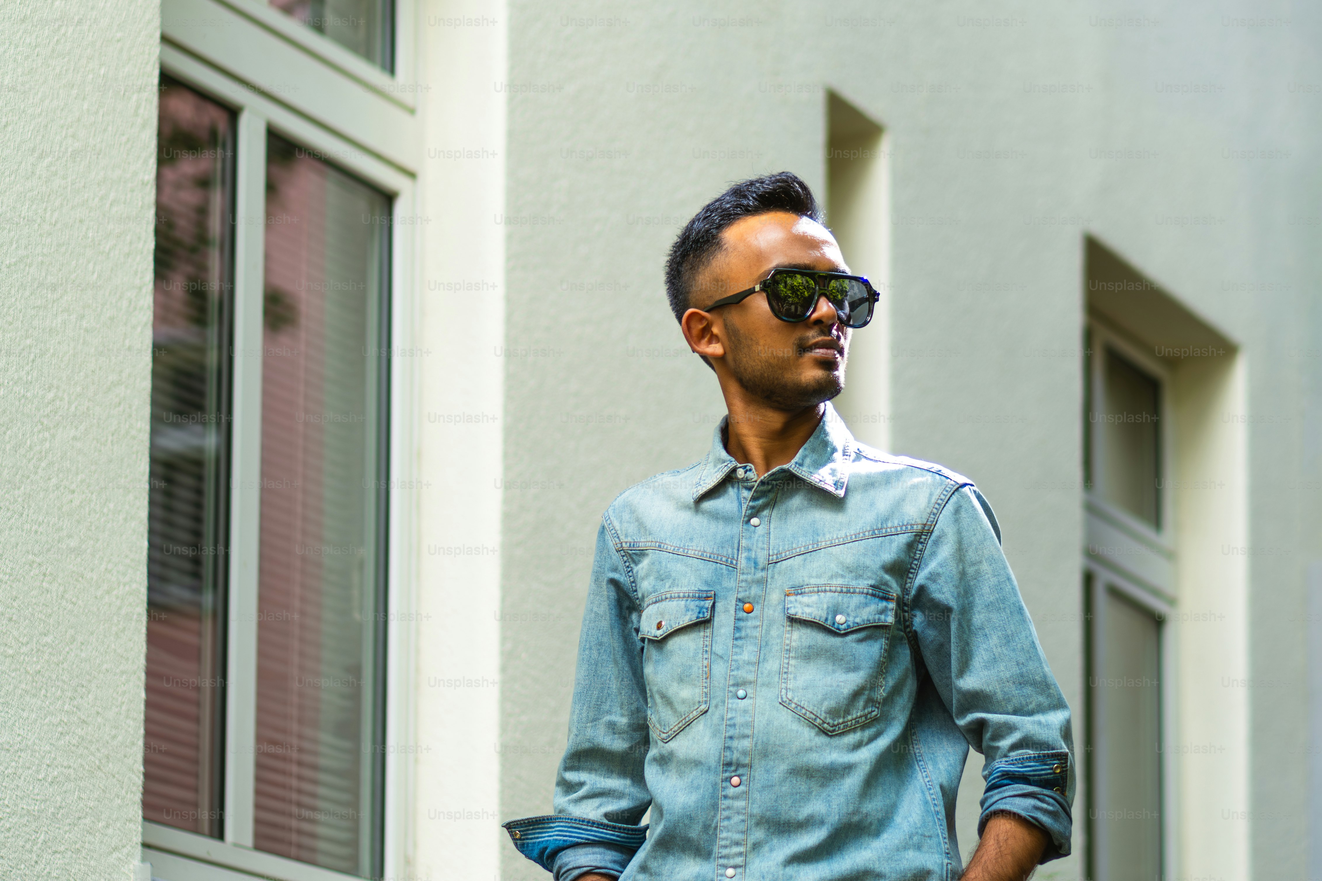 A man standing in front of a building photo – Moden man Image on Unsplash