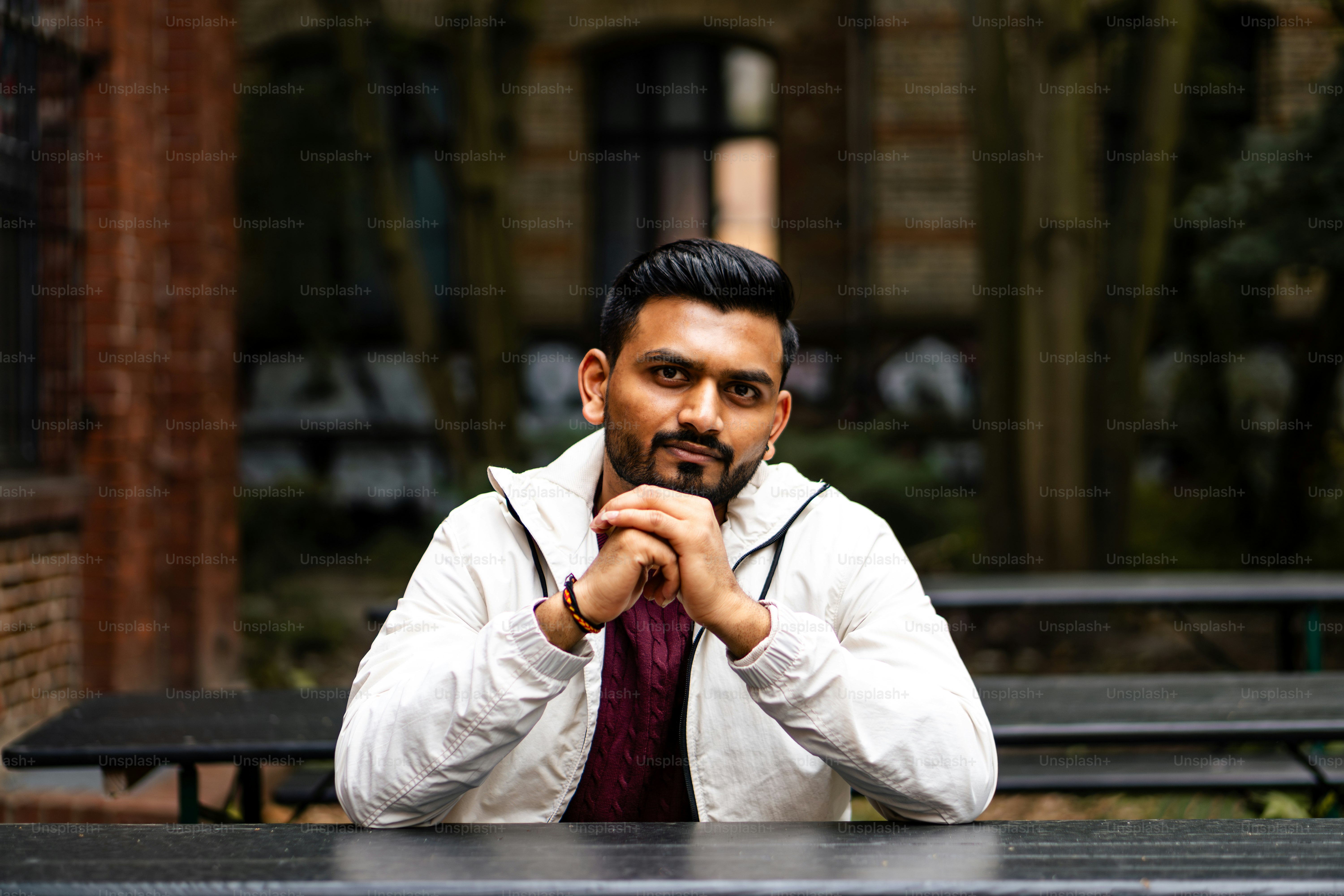 A man sitting at a table with his hands folded