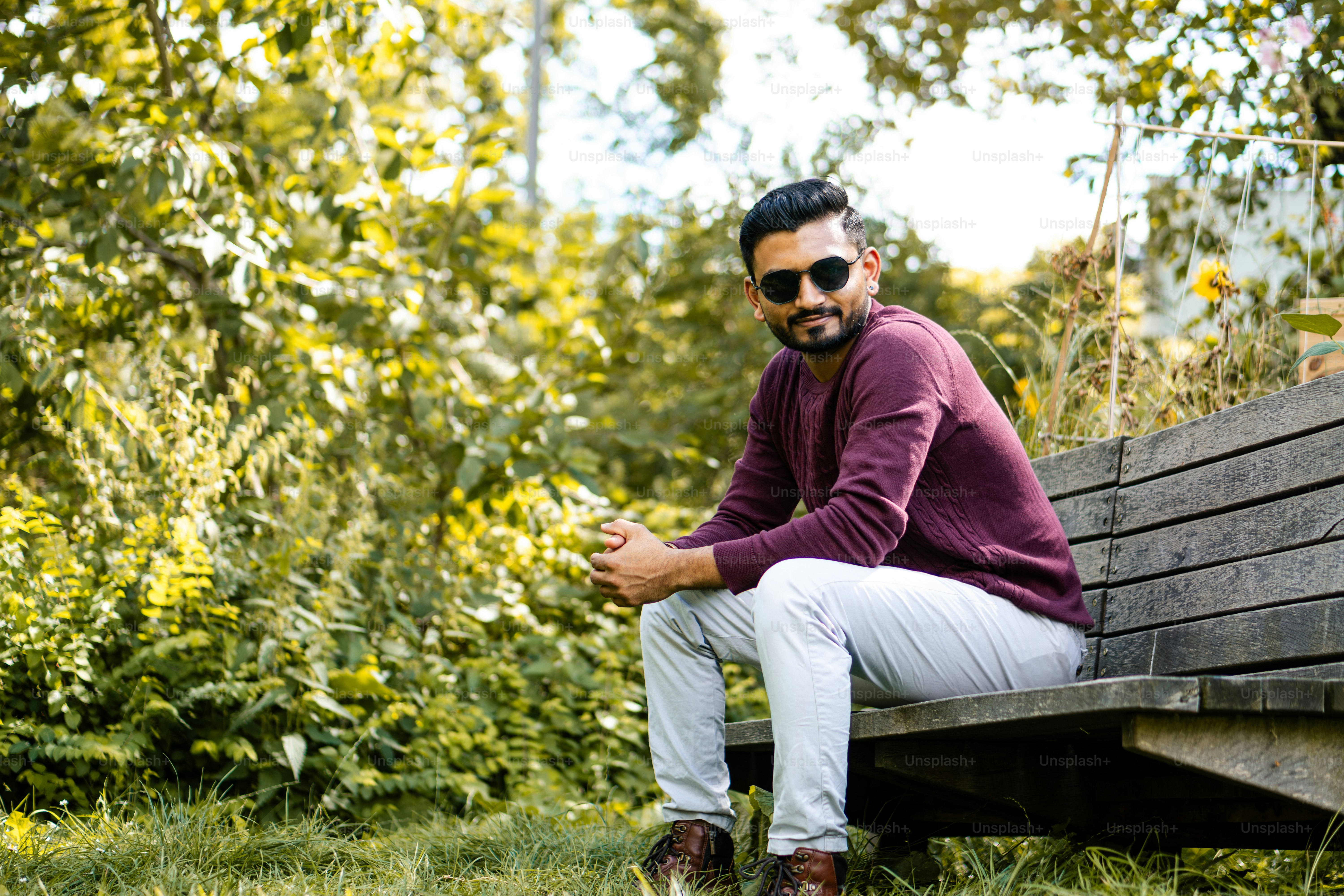 A man sitting on top of a wooden bench