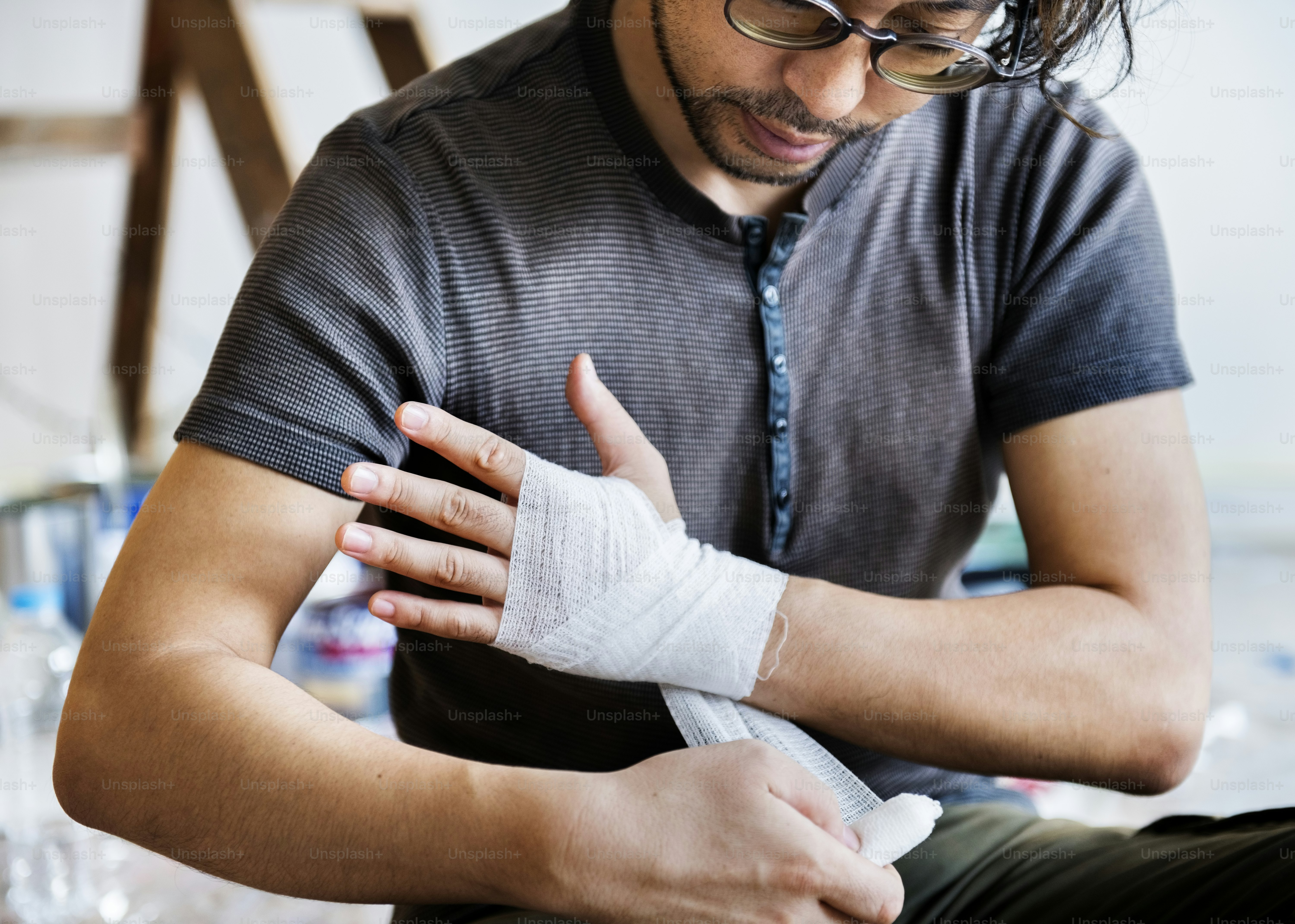 Homme enveloppant la main blessée avec un bandage