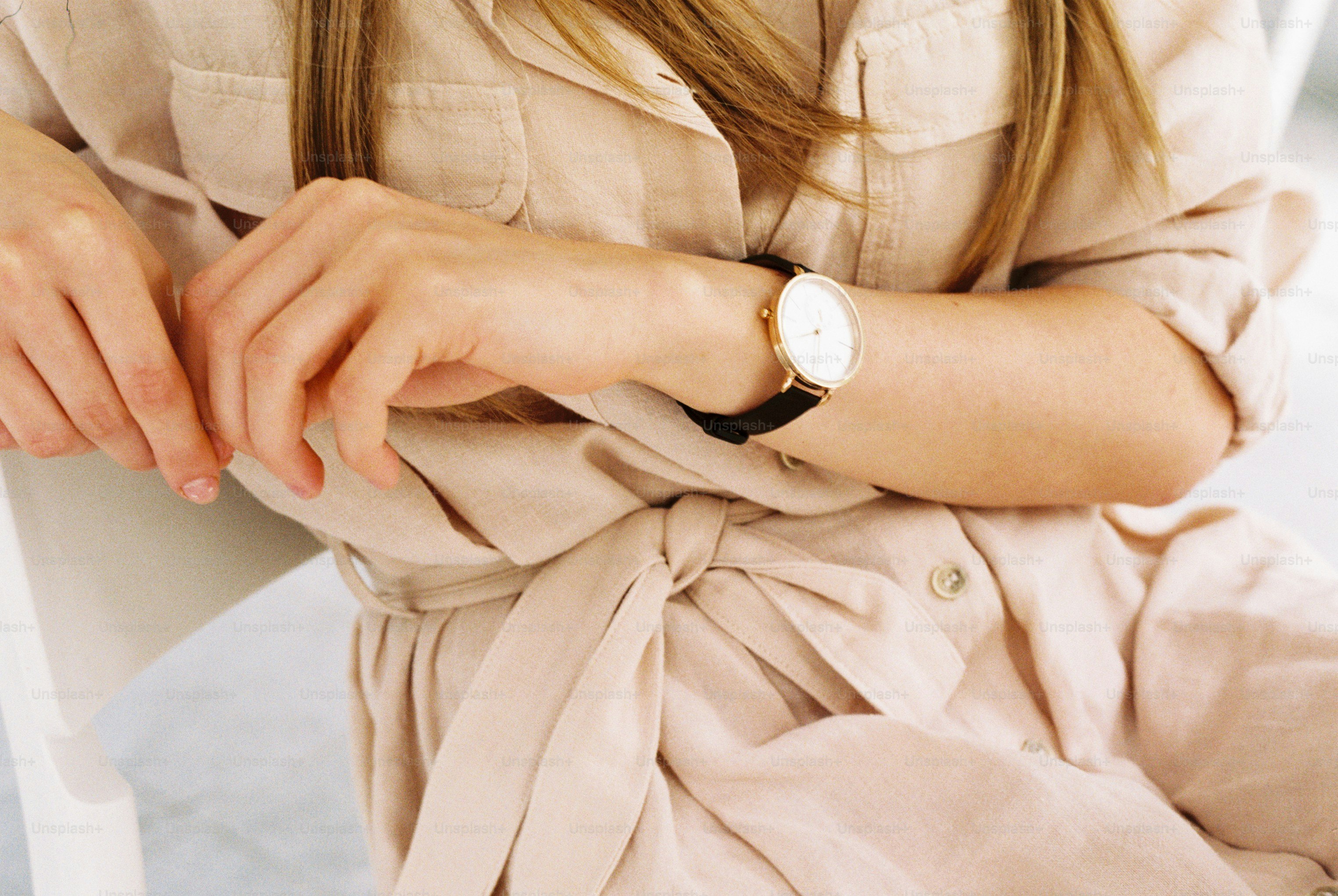 A woman sitting on a white chair wearing a watch photo – Neutral ...