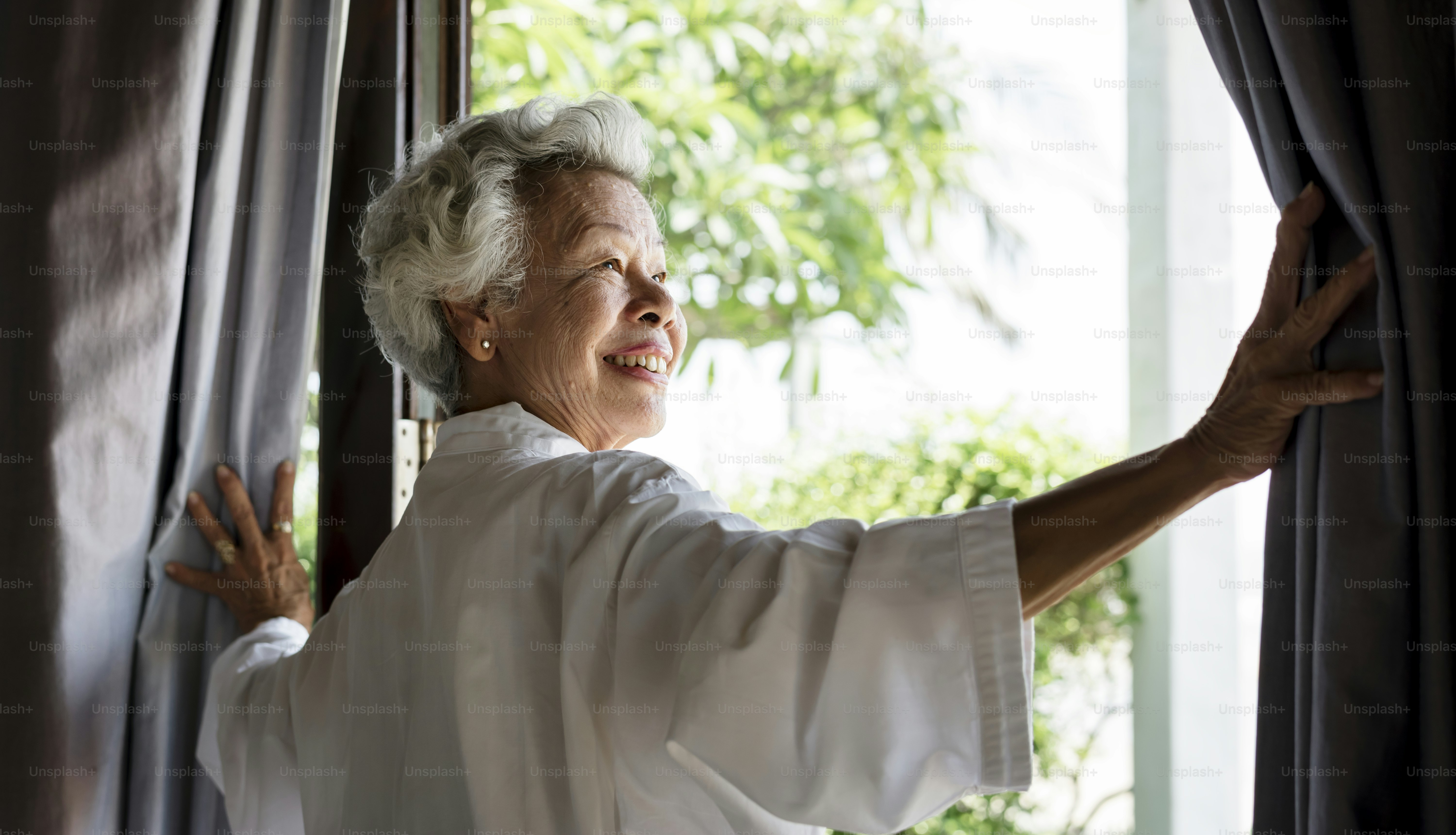Senior woman opening the curtains