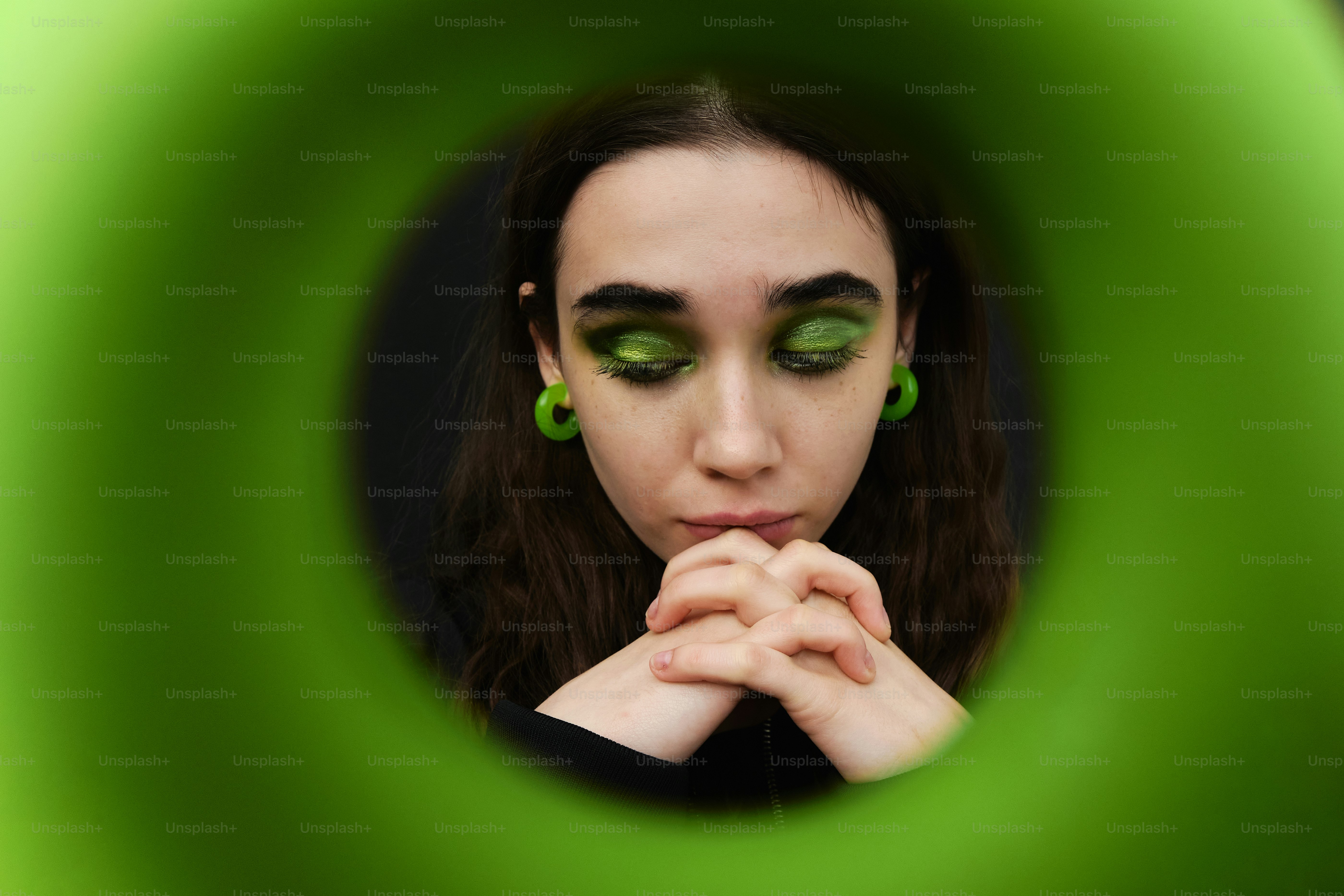 Uma mulher com olhos verdes olhando através de um tubo verde