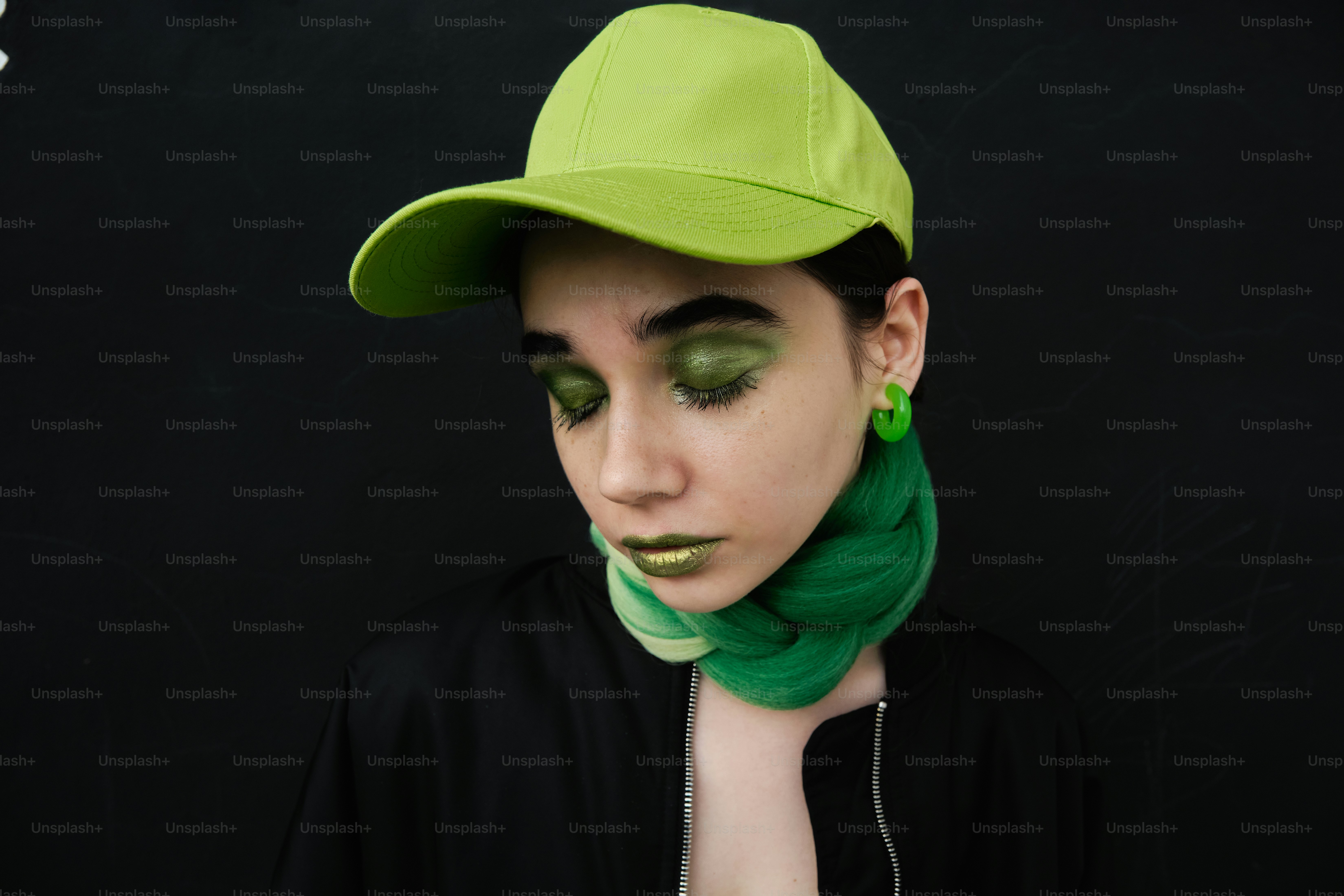 Una donna con trucco verde e cappello verde