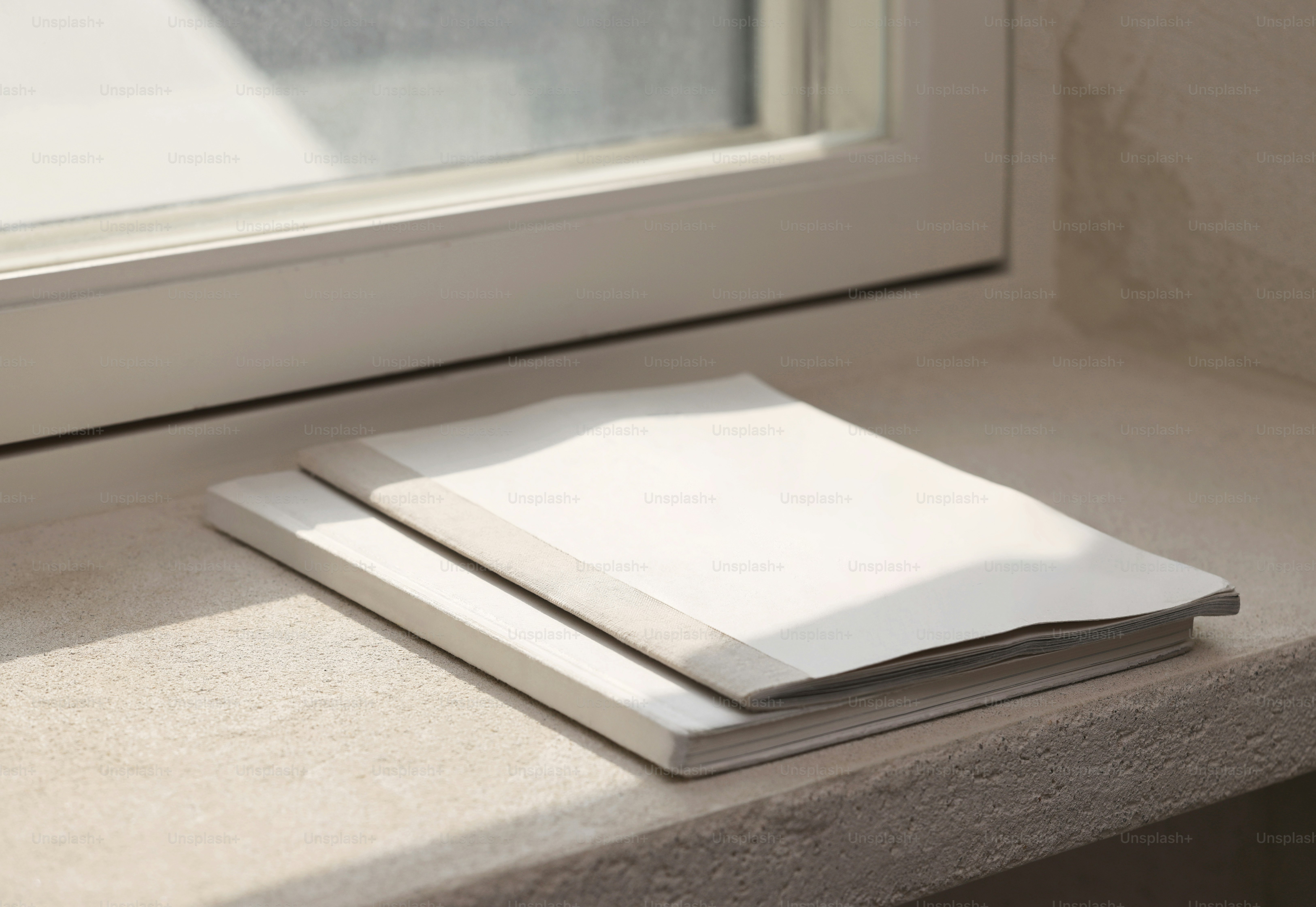 A single envelope resting on a windowsill, sunlight cutting across it as dust motes drift through the quiet air.