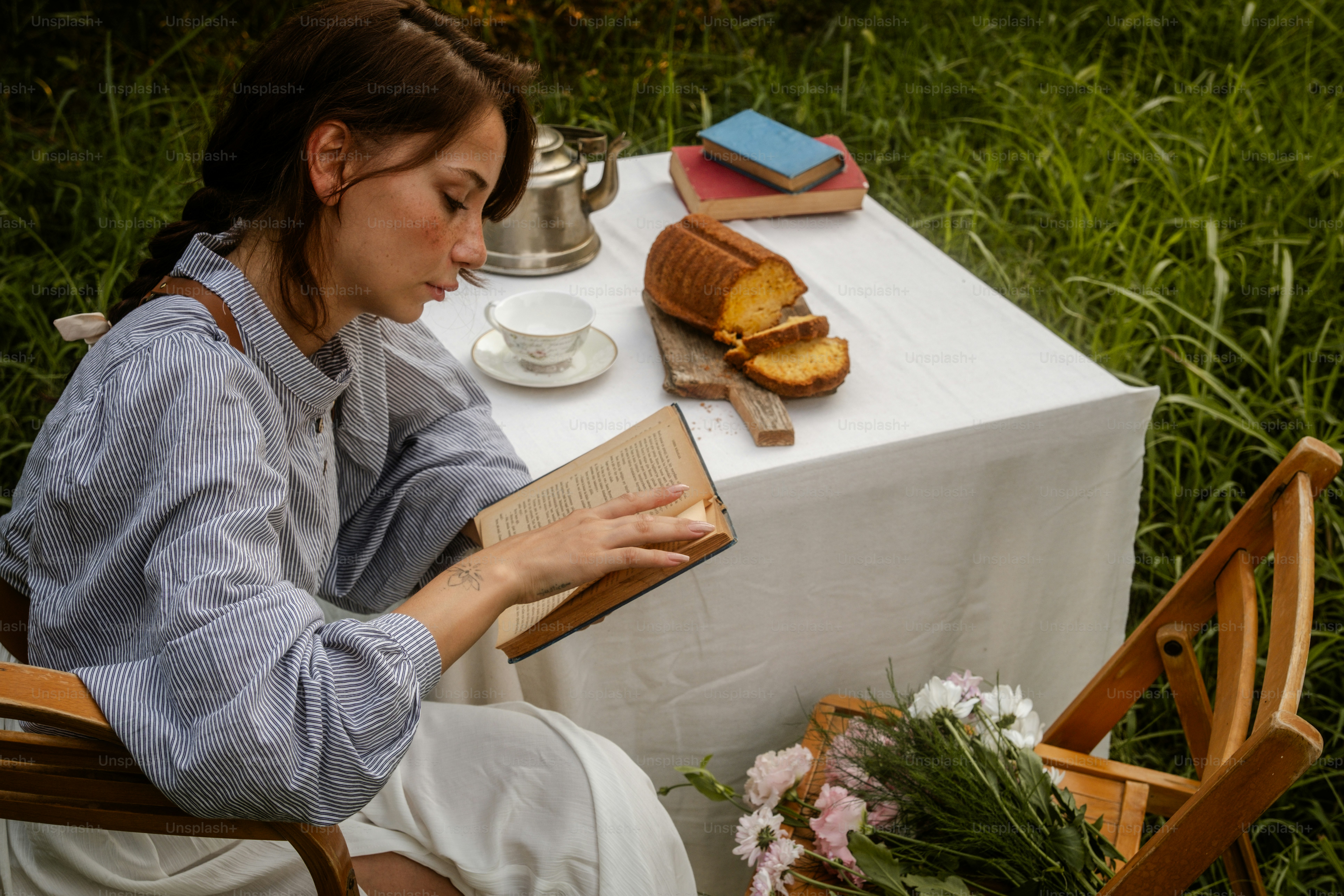 A woman sitting at a table reading a book