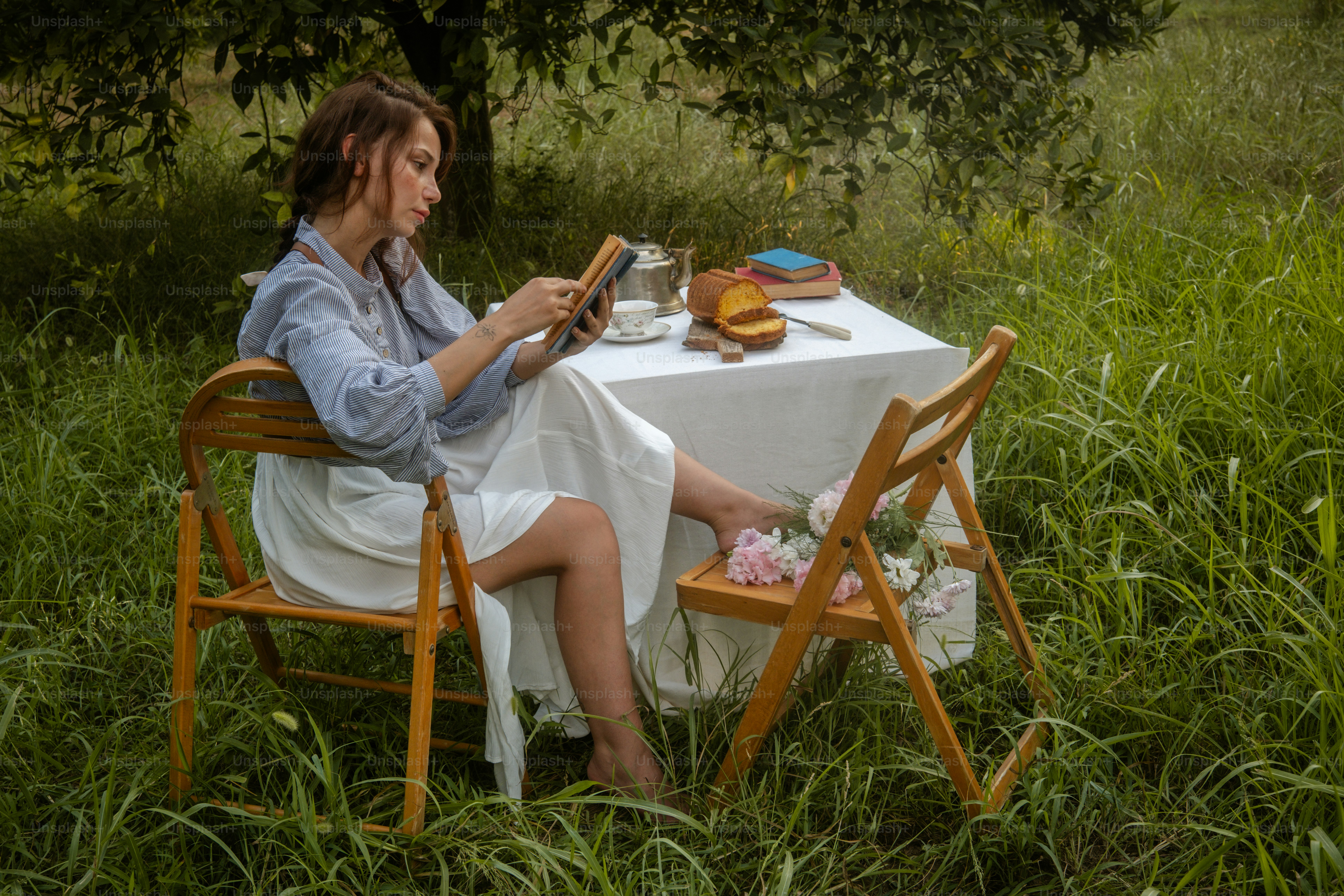 A woman sitting at a table in the middle of a field
