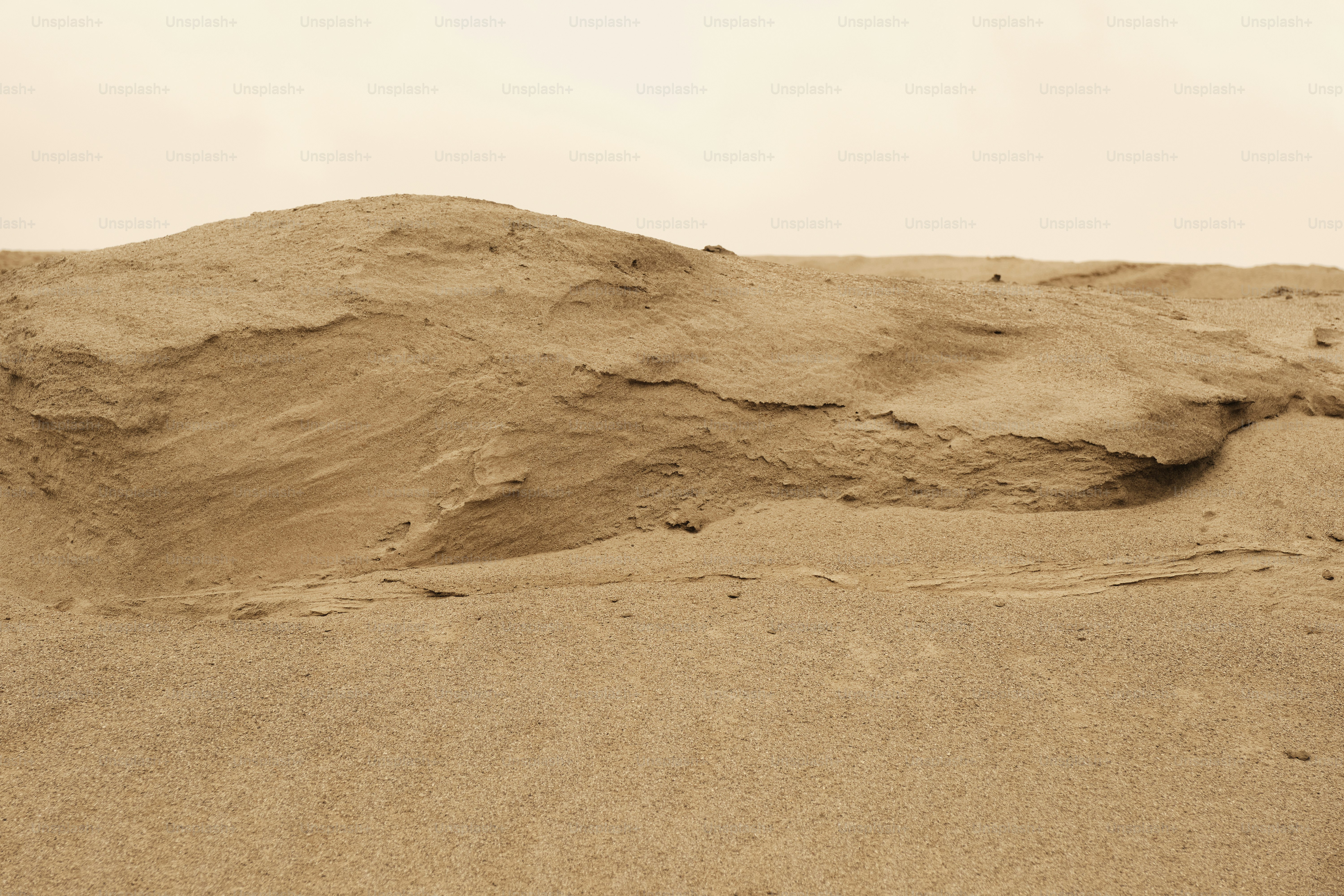A person standing in the sand with a surfboard