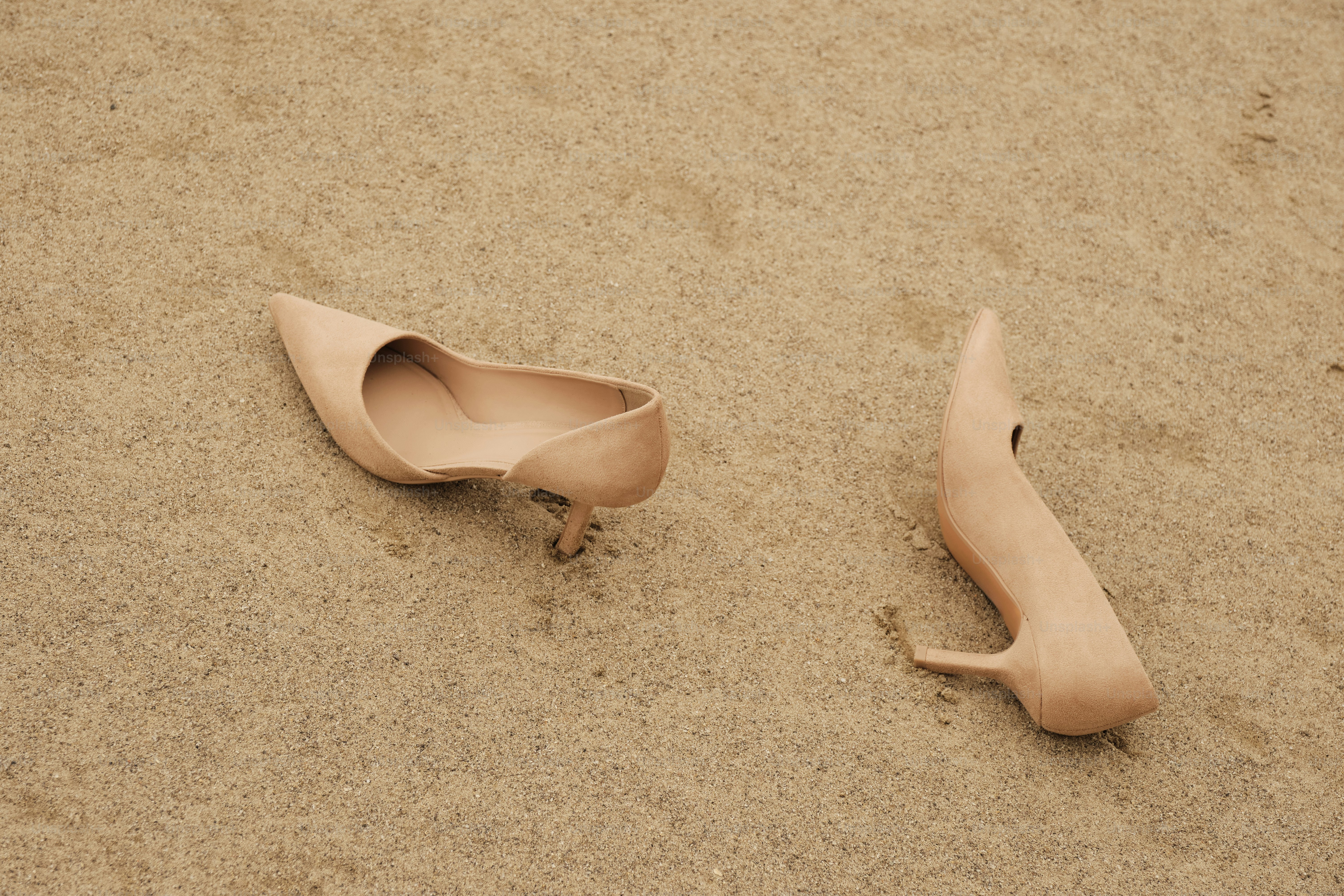A pair of shoes that are laying in the sand