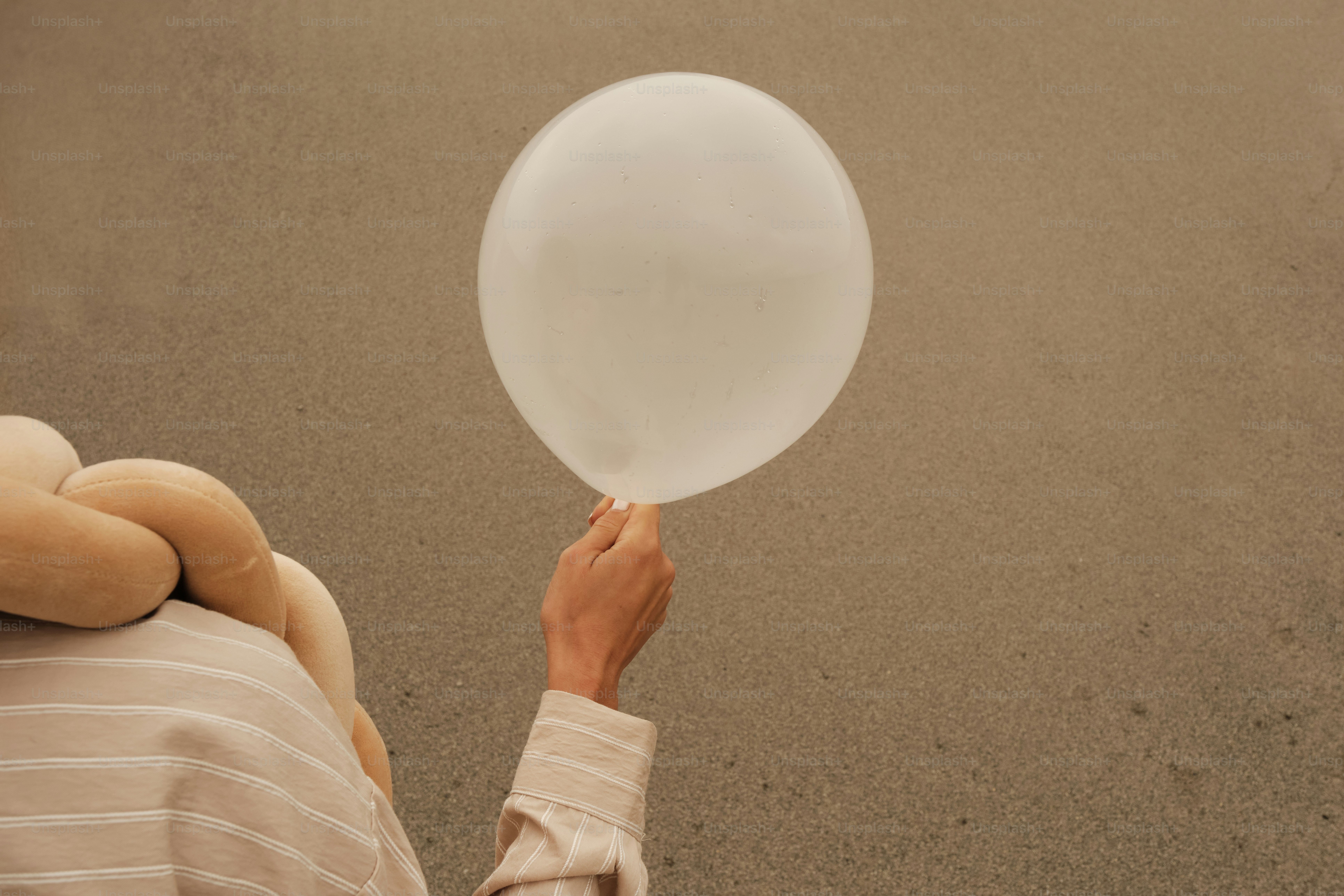 Eine Person, die einen weißen Luftballon in die Luft hält