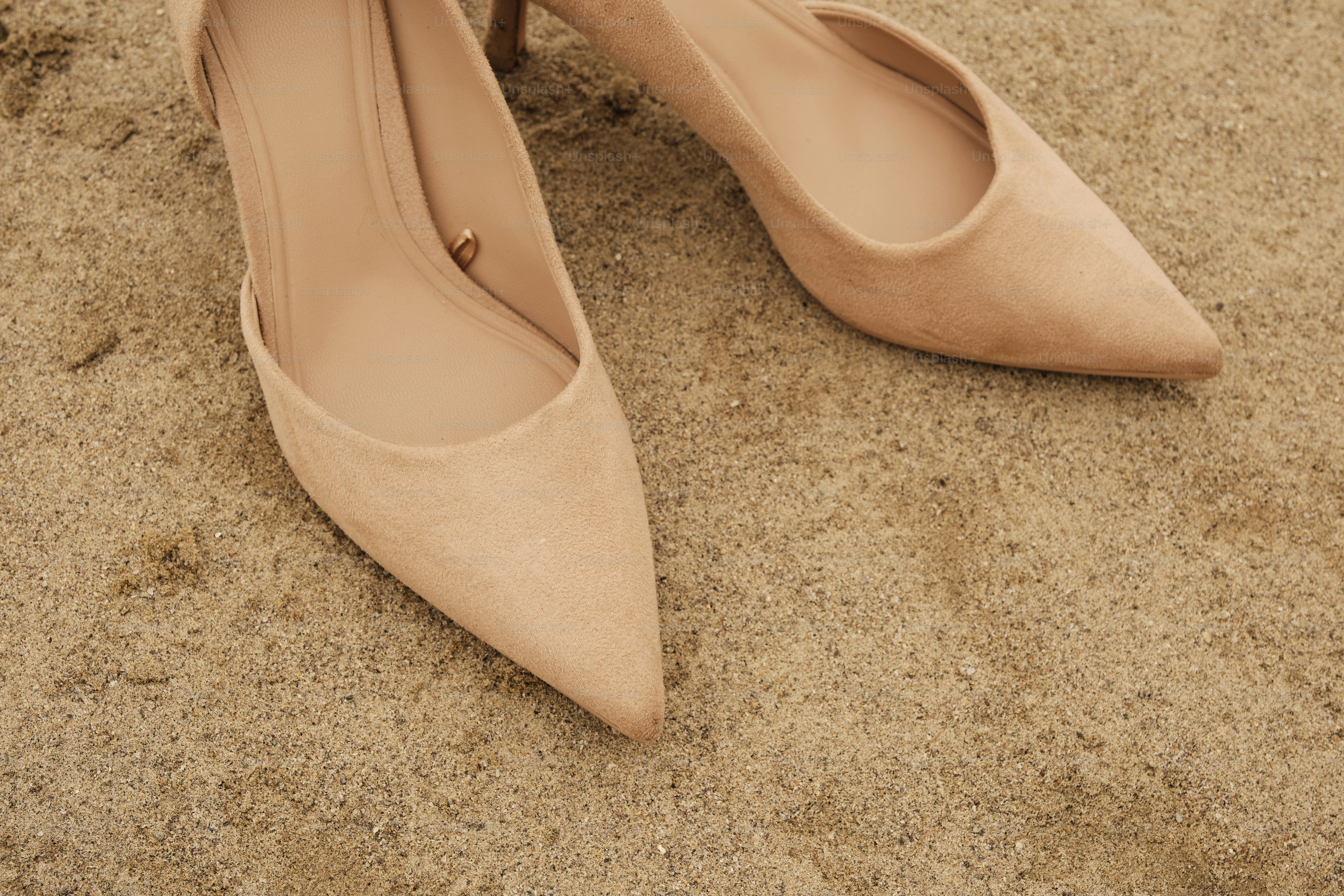 Un paio di scarpe nude sedute in cima a una spiaggia sabbiosa