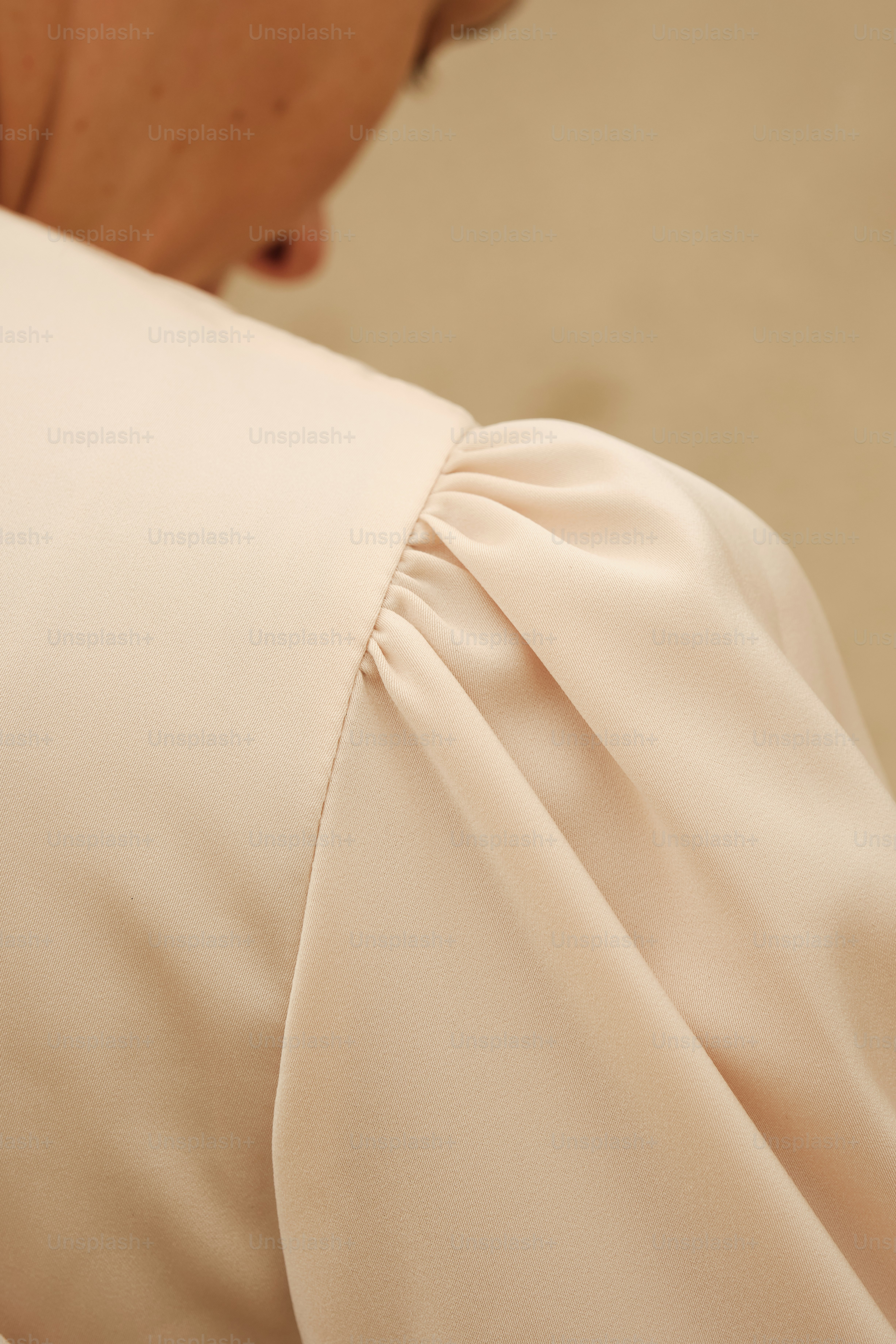 Eine Frau in einem weißen Kleid schaut auf ihr Handy