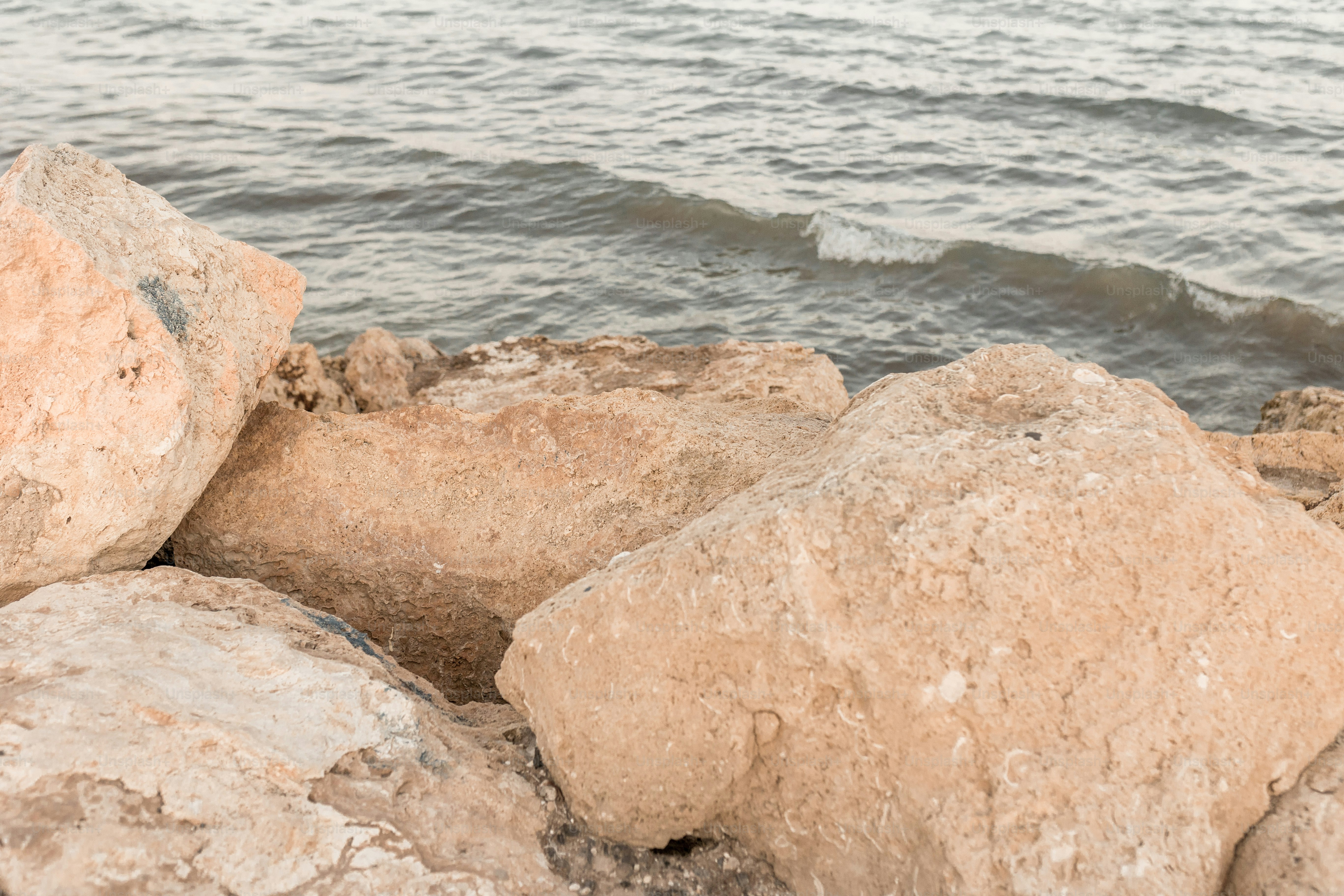 A couple of rocks sitting on top of a beach