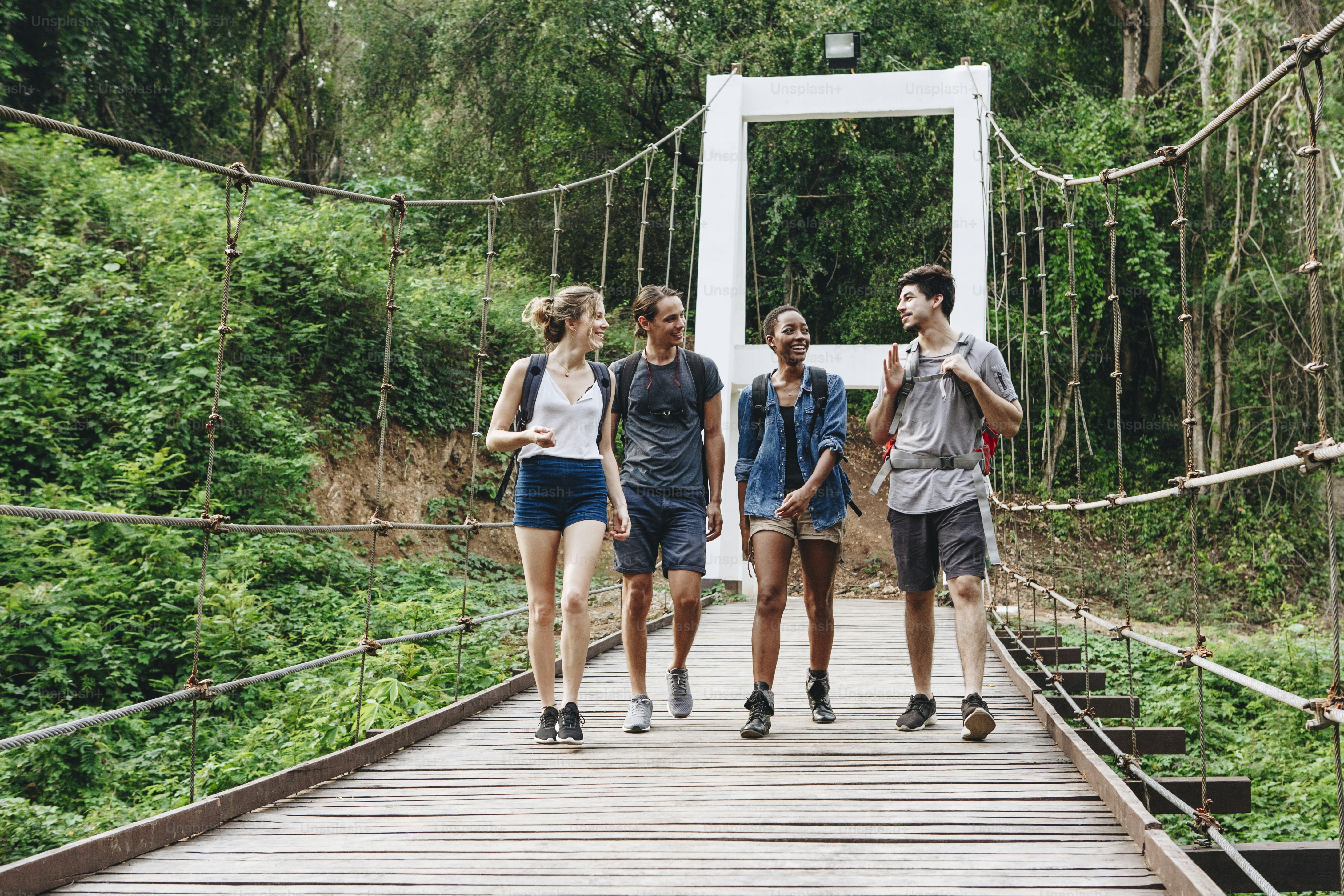 Freunde, die auf einer Brücke in der Natur spazieren gehen