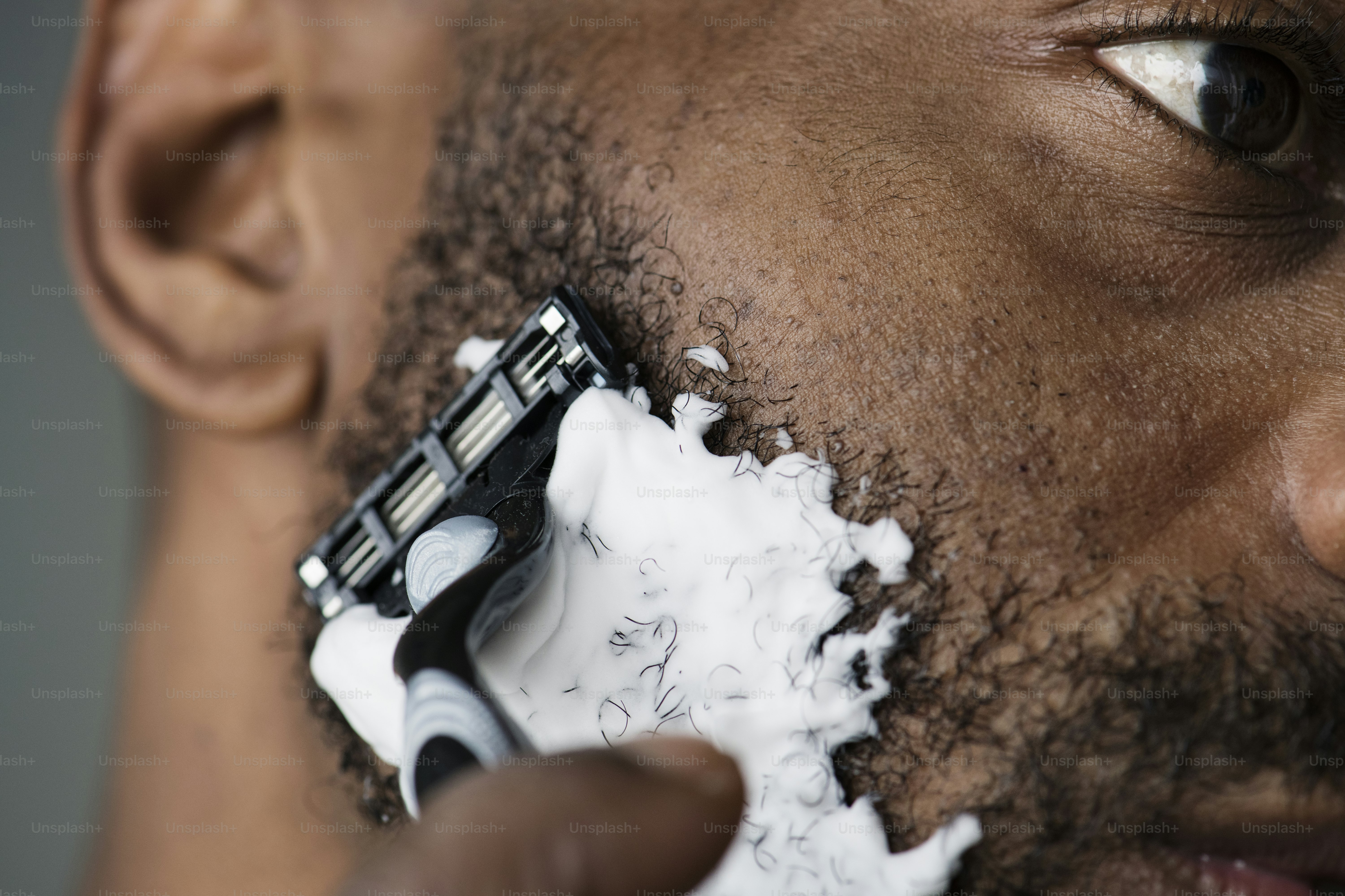 Black man shaving his beard