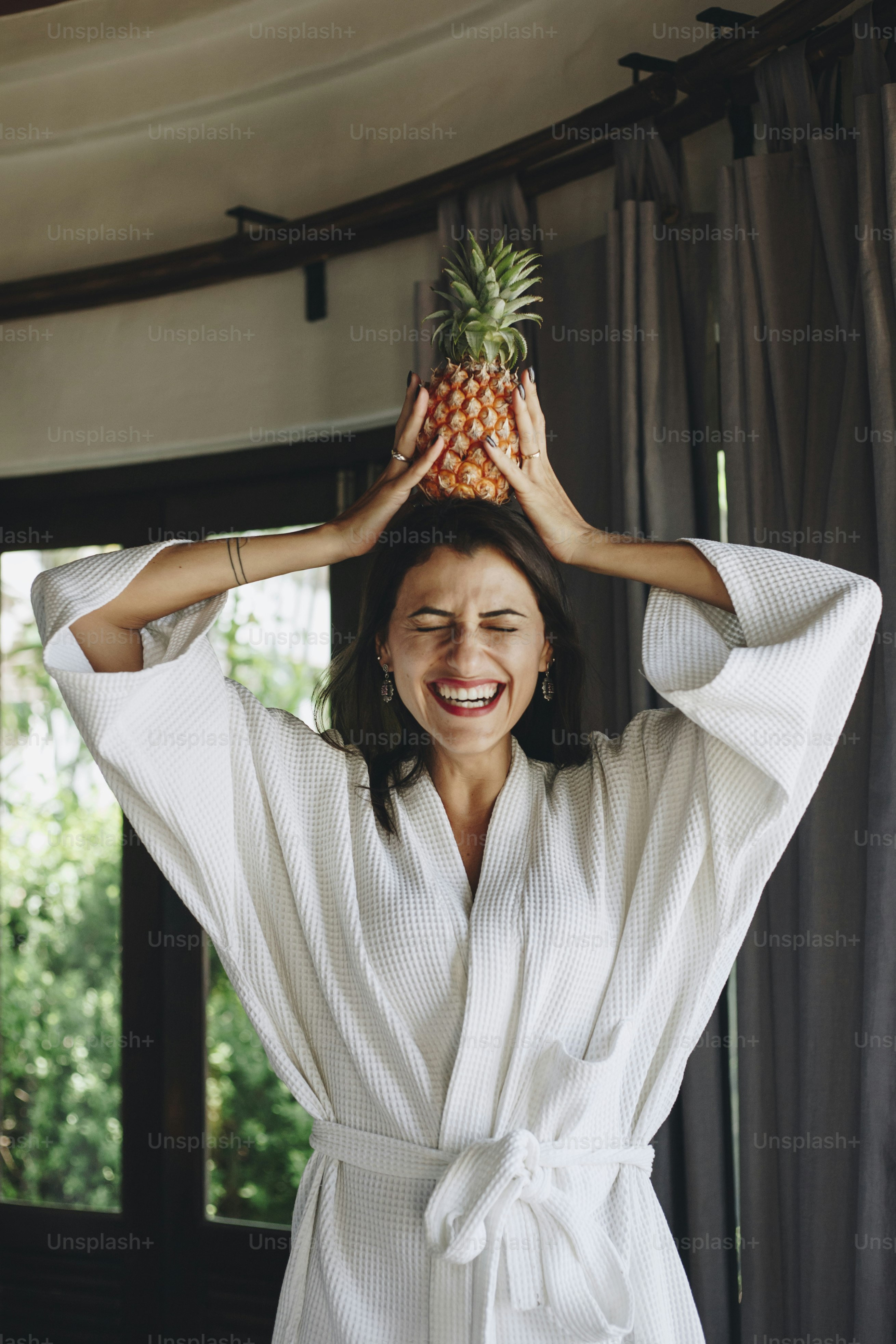 Woman in a bathrobe holding a pineapple